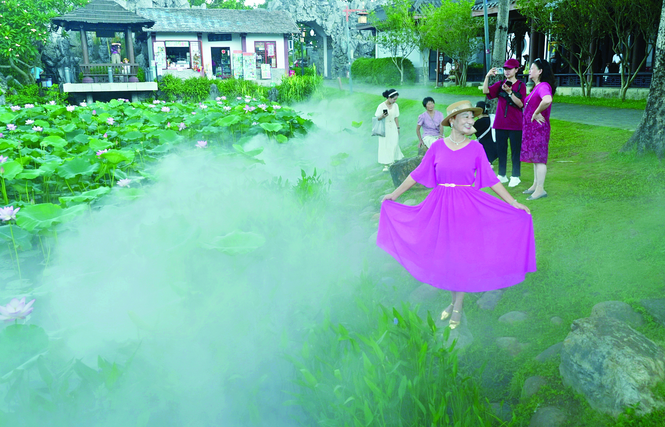     游客在丰渚园荷塘边留影。