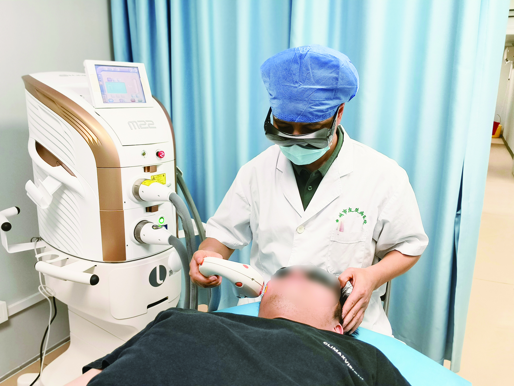     ▲医生操作M22仪器为患者进行治疗。