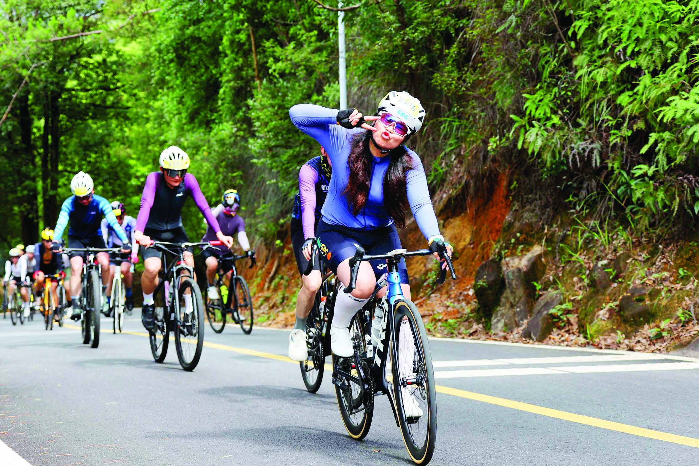 <p>    参加骑行活动的一名女骑手边骑行边与记者互动。    惠州日报记者李松权 摄</p>