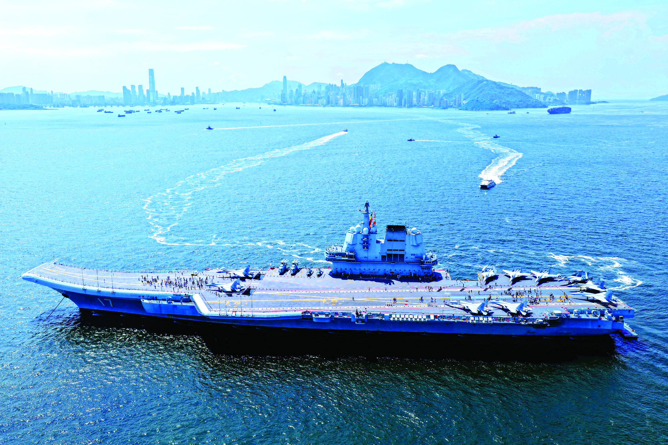     7月4日，锚泊在维多利亚港的山东舰对香港青少年学生开放，参观者通过换乘的方式登舰（无人机照片）。新华社发