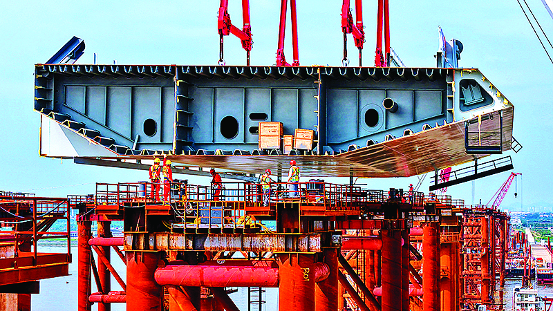     施工人员在位于广州南沙区的万龙大桥钢梁支架上接收首节钢箱梁。新华社发