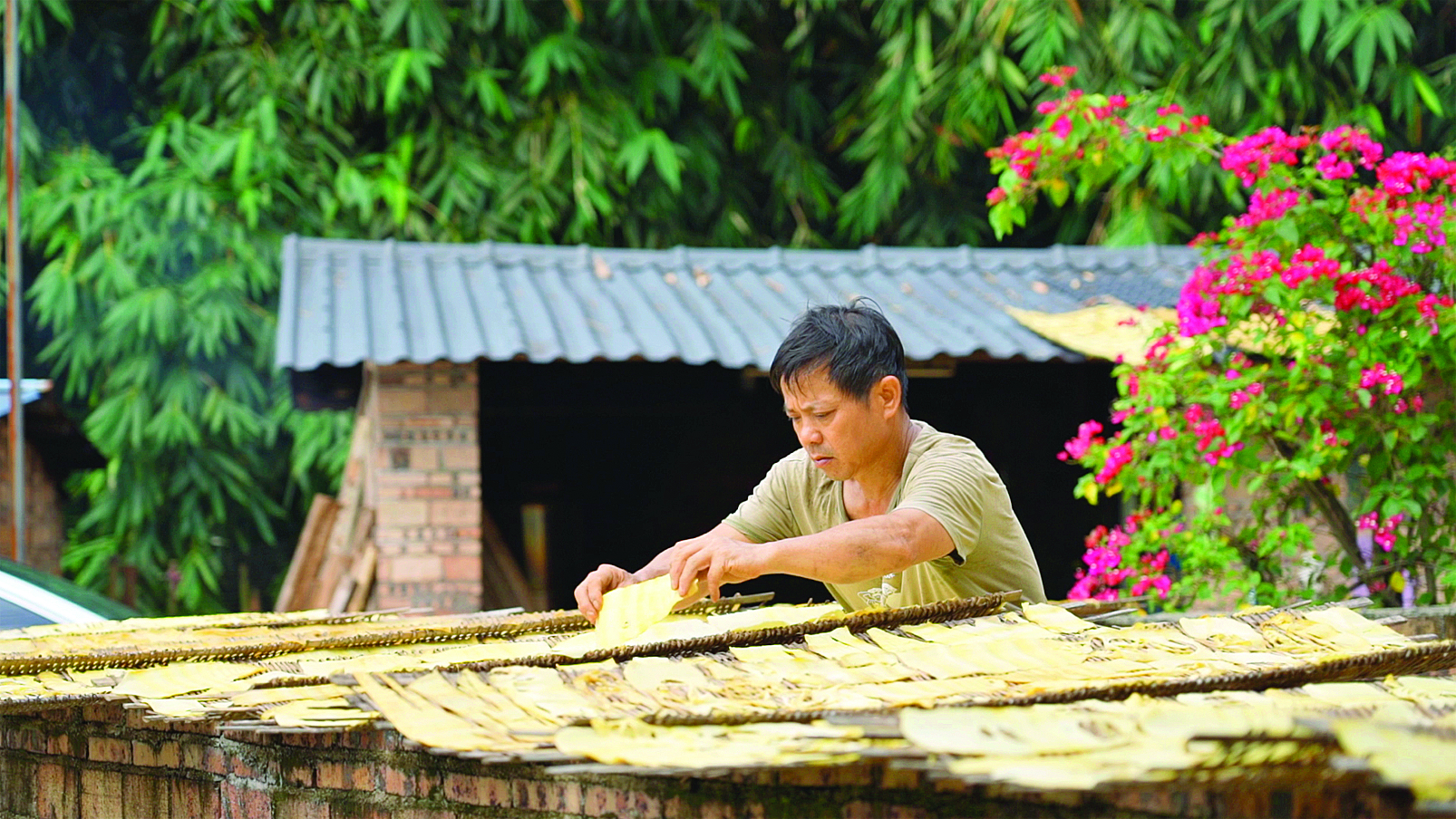     村民将笋片均匀地铺在竹匾上。