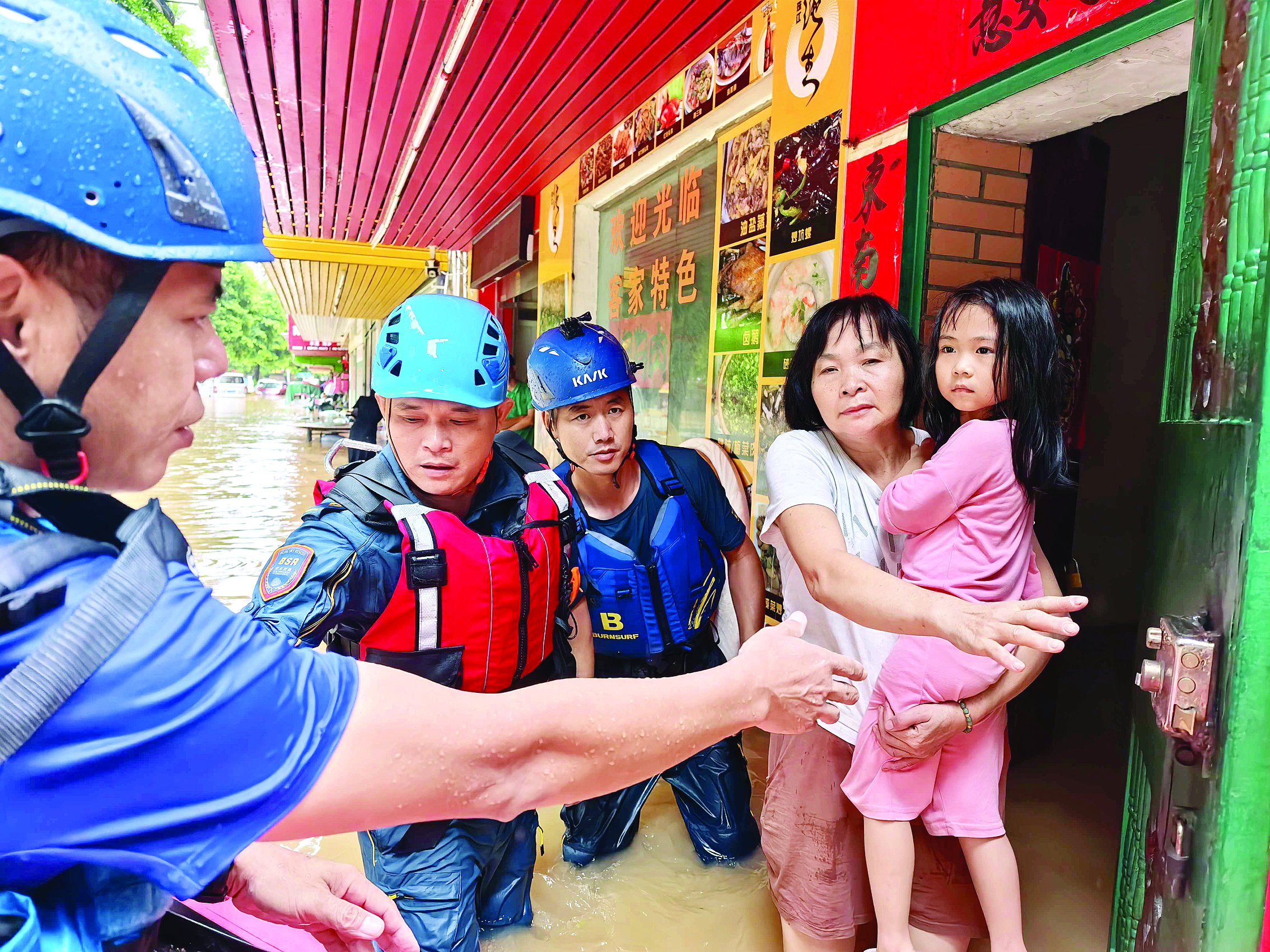     蓝天救援队在惠阳淡水街道桥背街转移需要救援的一家四口。    惠州日报记者谢宝树 摄