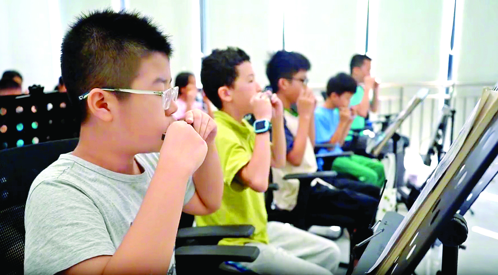     在暑期公益艺术培训班上，孩子们饶有兴趣地学习吹口琴。    惠州日报记者黄宇翔 通讯员龙融心 摄