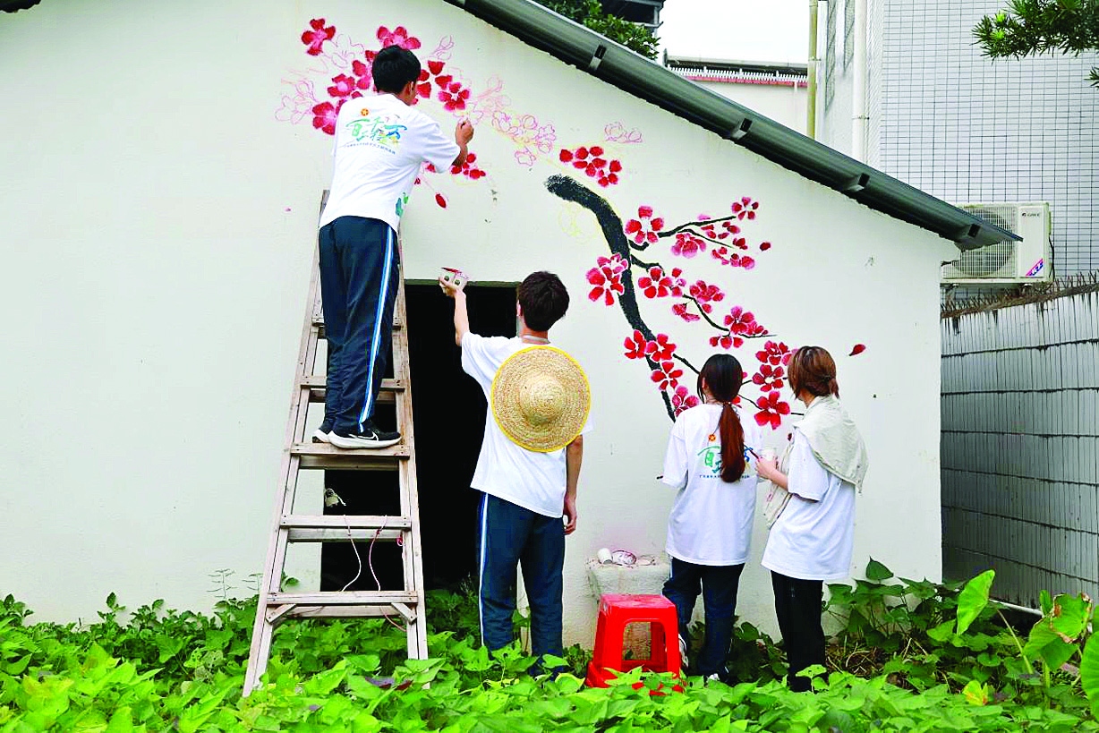     青年学子主动承接墙绘任务，为乡村颜值“增色”。惠州日报记者赖金朗 摄