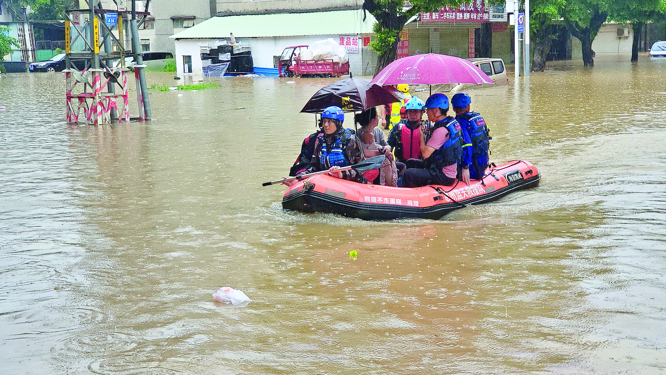     惠州日报记者李松权（右二）在摇晃的冲锋舟上用手机直播。惠州日报记者谢宝树 摄
