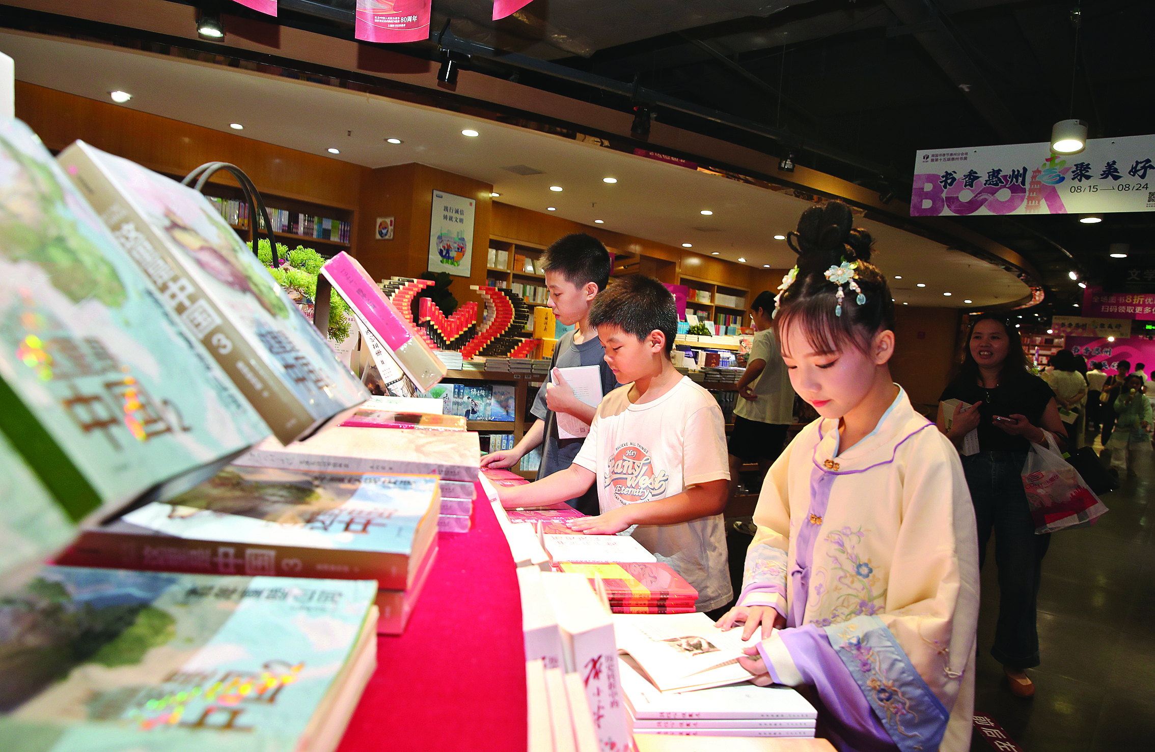     8月15日上午，一群小读者在2025南国书香节惠州分会场暨第十五届惠州书展阅读图书。惠州日报记者钟畅新 摄