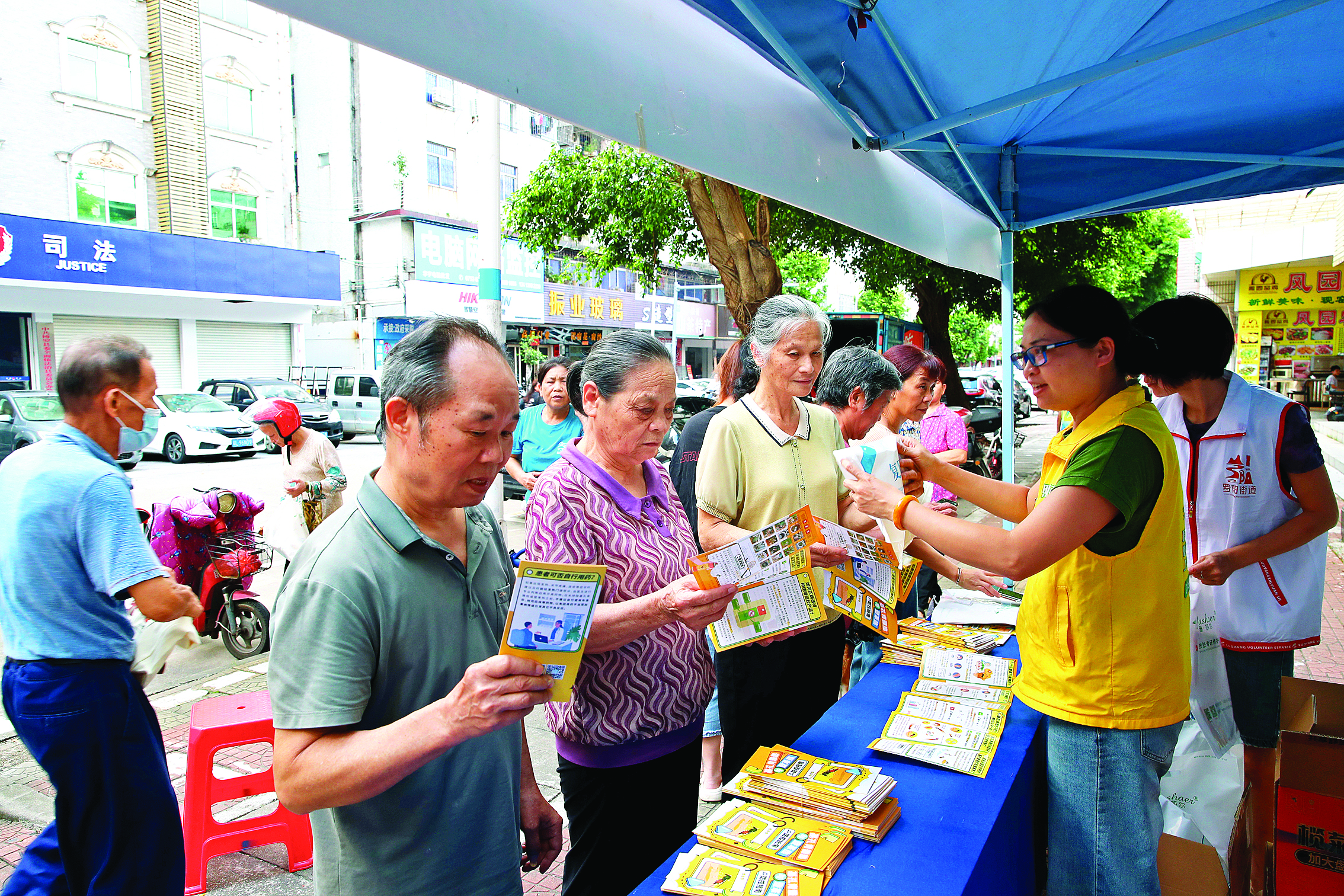     市民领取防蚊灭蚊药物和宣传资料。    惠州日报记者钟畅新 摄