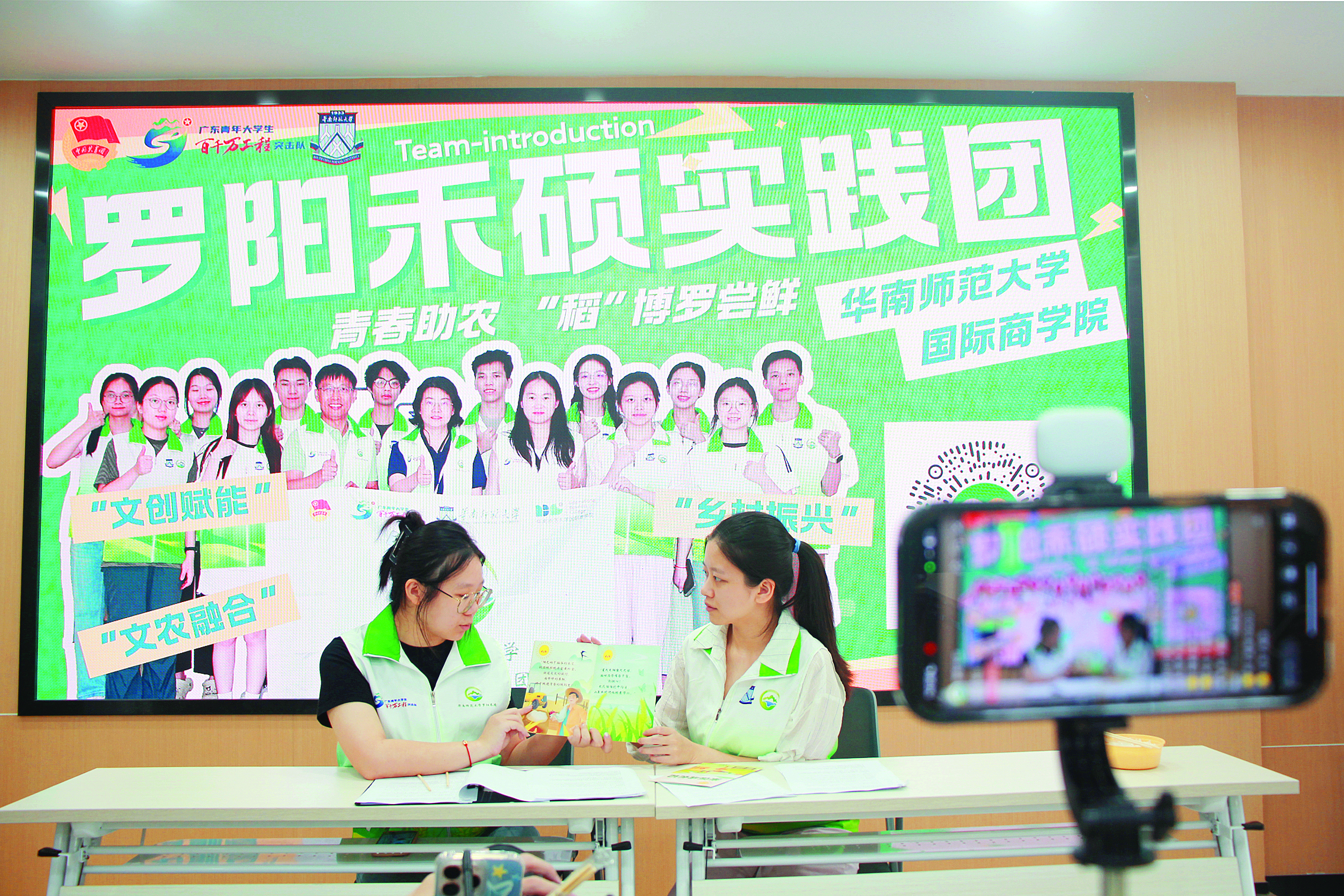     实践团成员在直播间展示绘本。“罗阳禾硕”实践团供图