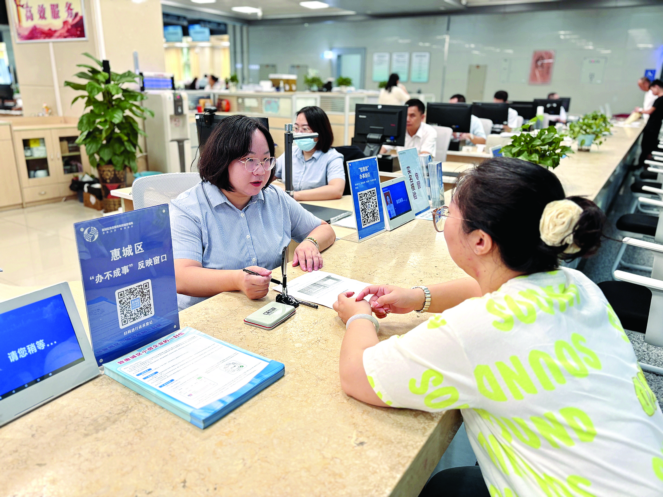     群众在窗口办理业务。惠州日报记者谢菁菁 摄