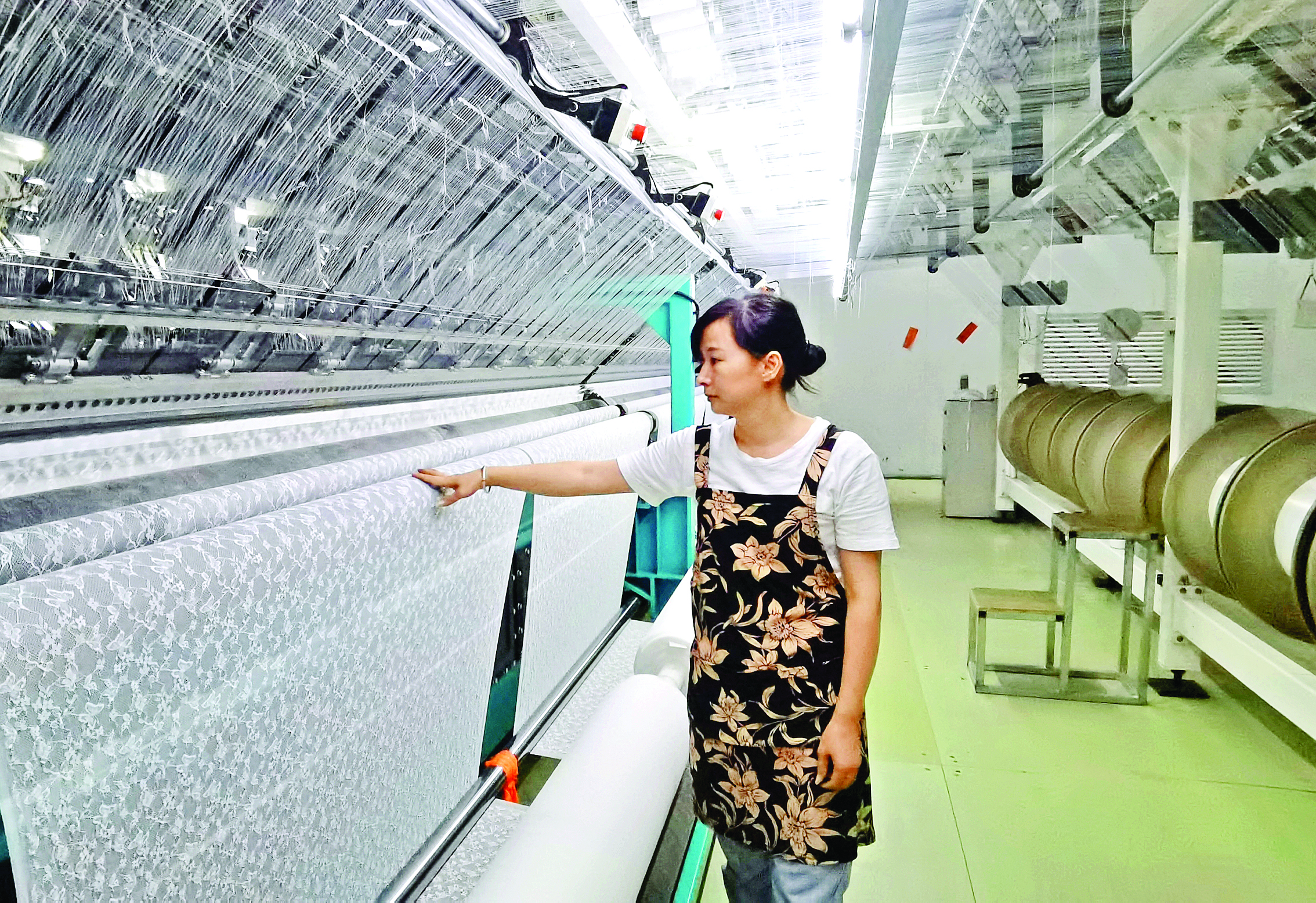     位于园洲镇的广东中康织绣科技有限公司生产车间里，工人正检查蕾丝生产情况。惠州日报记者朱丽婷 摄