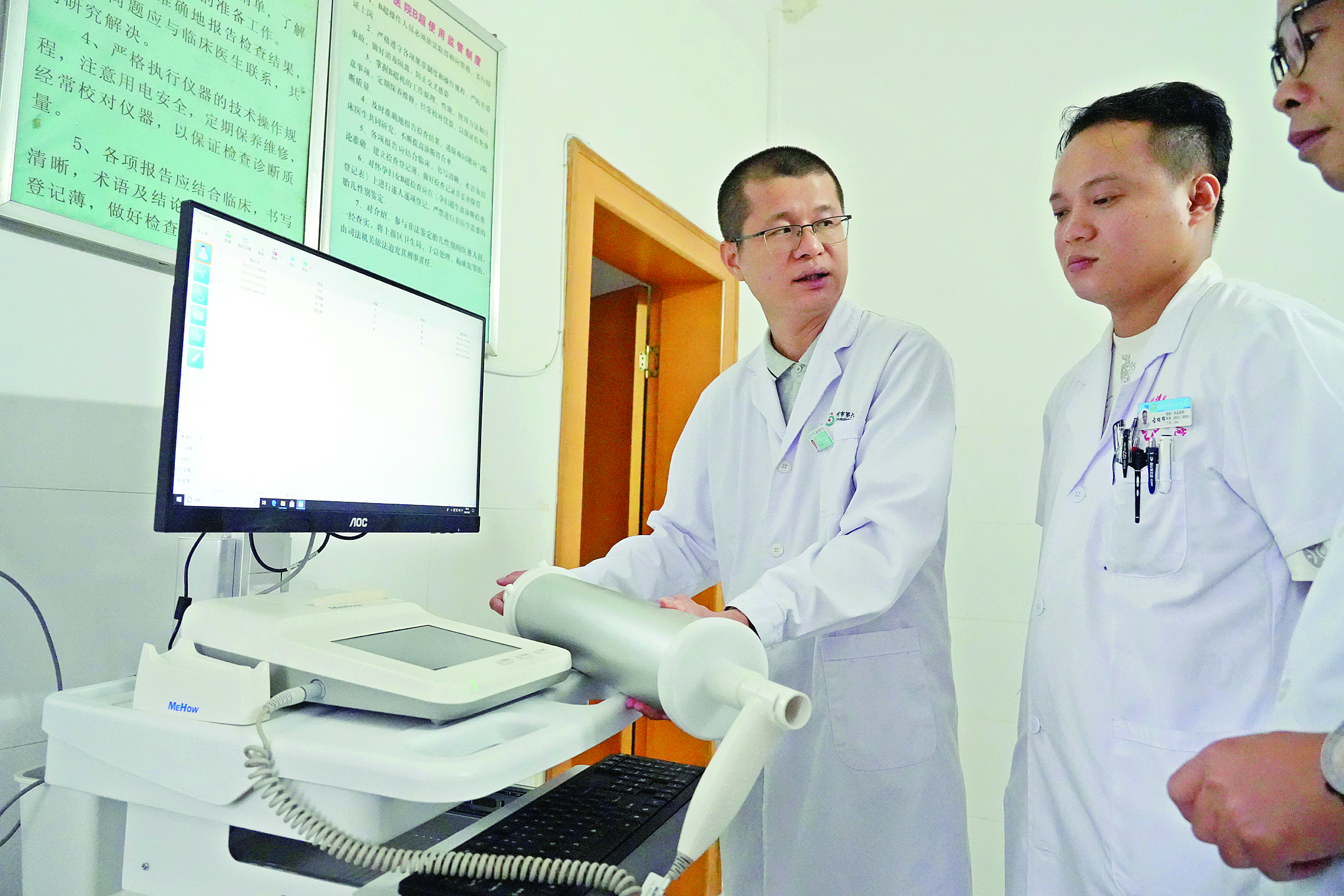     叶日康（左一）指导沙田镇中心卫生院医生规范使用医疗设备。    惠州日报记者许文昌 摄
