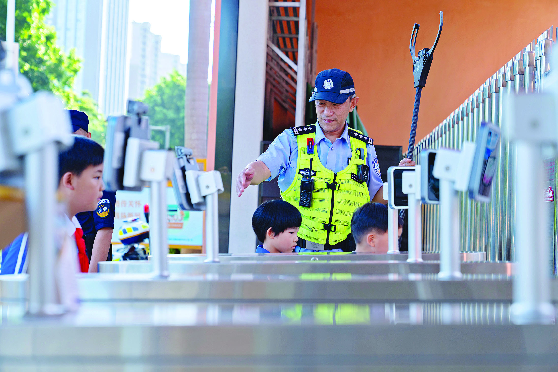     民警在校门口维护秩序，学生们有序返校。市公安局供图