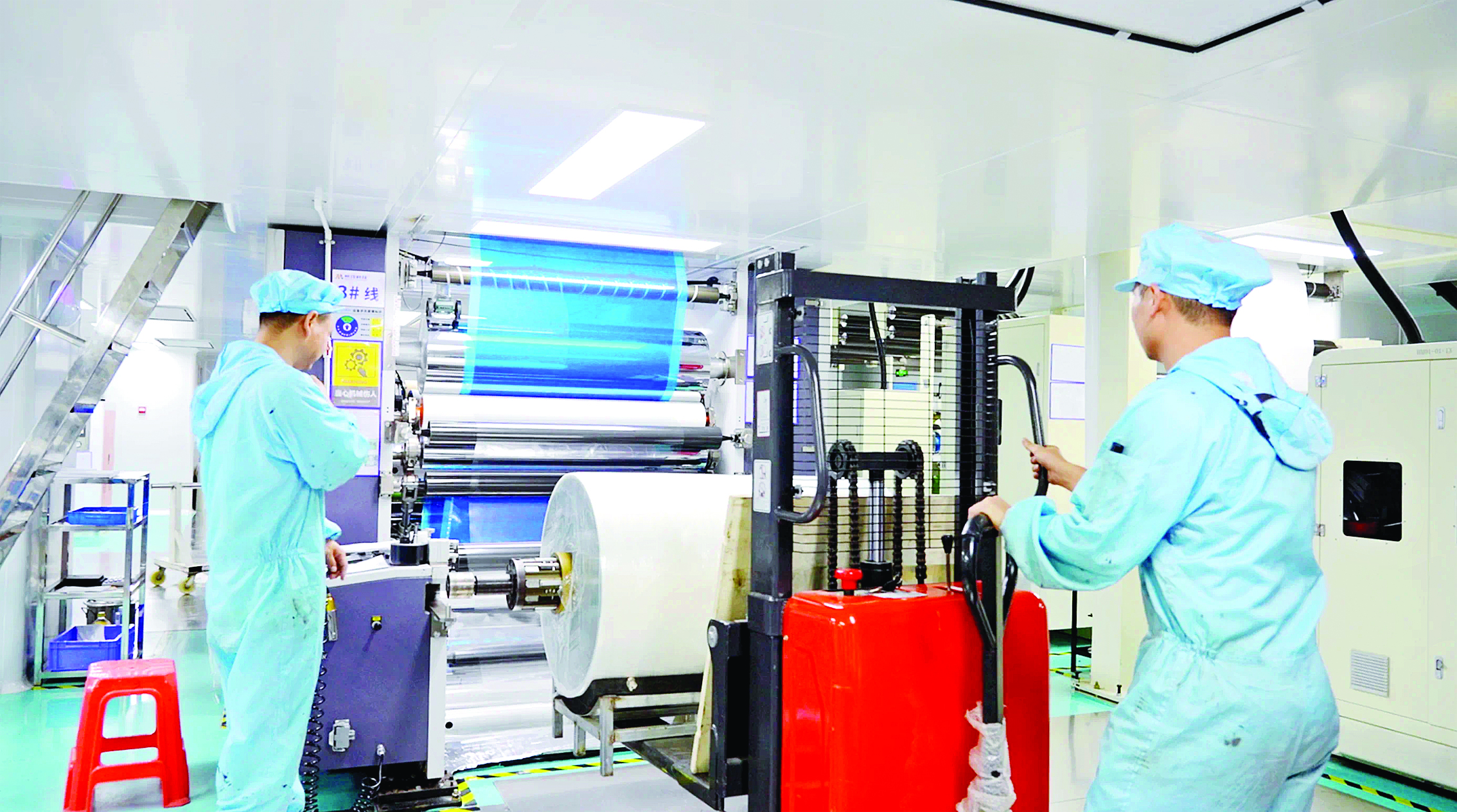     功能性薄膜新材料企业车间内，工人们正在检查产品。