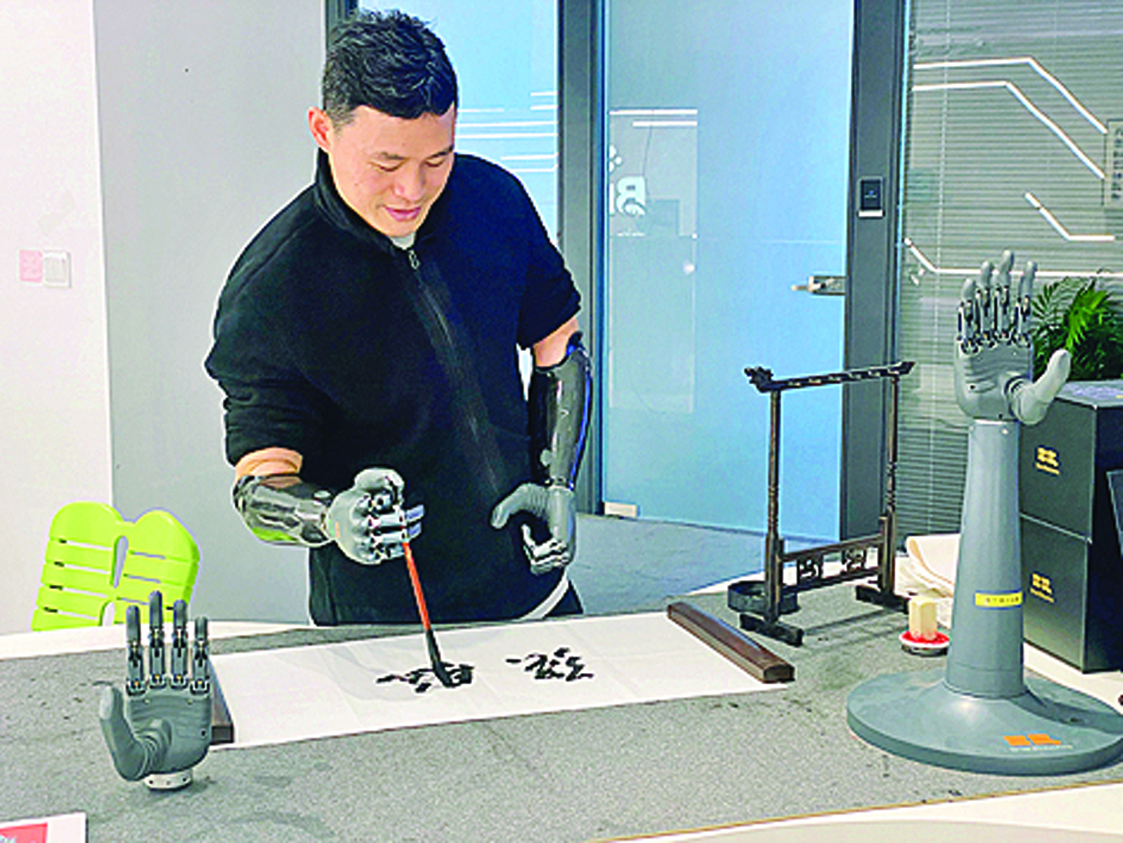     在浙江强脑科技有限公司展厅内，失去双手的产品体验官依靠智能仿生手写毛笔字。新华社发