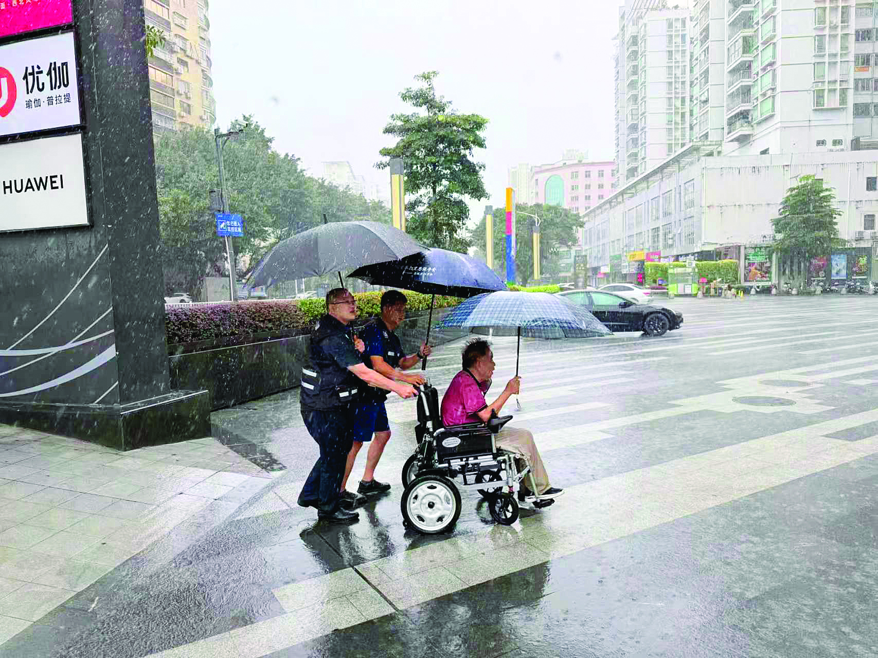     惠城区桥东街道应急人员帮助一位行路不便的老人回家。    惠州日报记者谢菁菁 通讯员吕昊东 摄