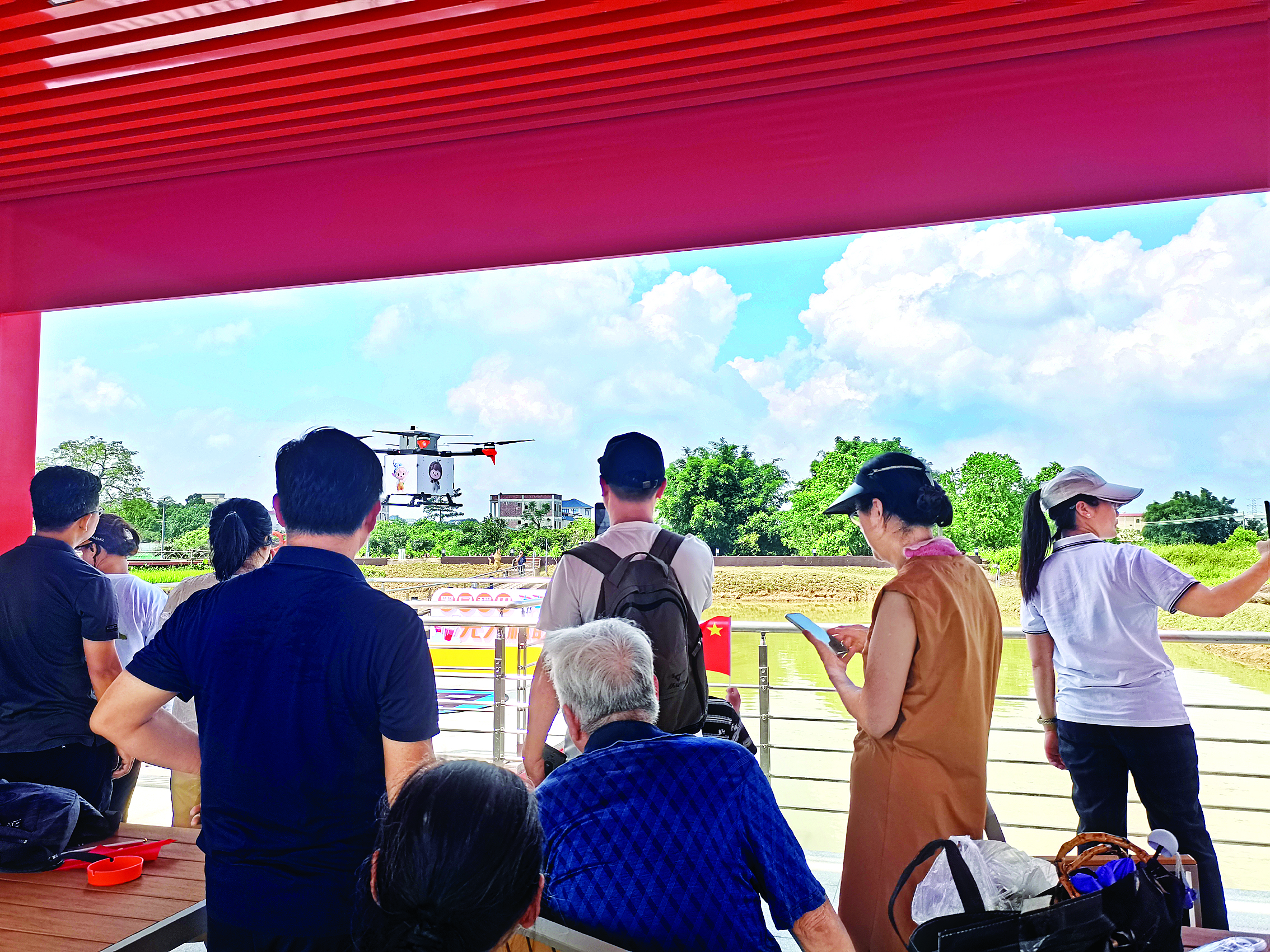     游客在惠城区横沥镇墨园村体验“无人机送咖”。惠州日报记者谢菁菁 特约通讯员匡赟 通讯员张雅拍 摄