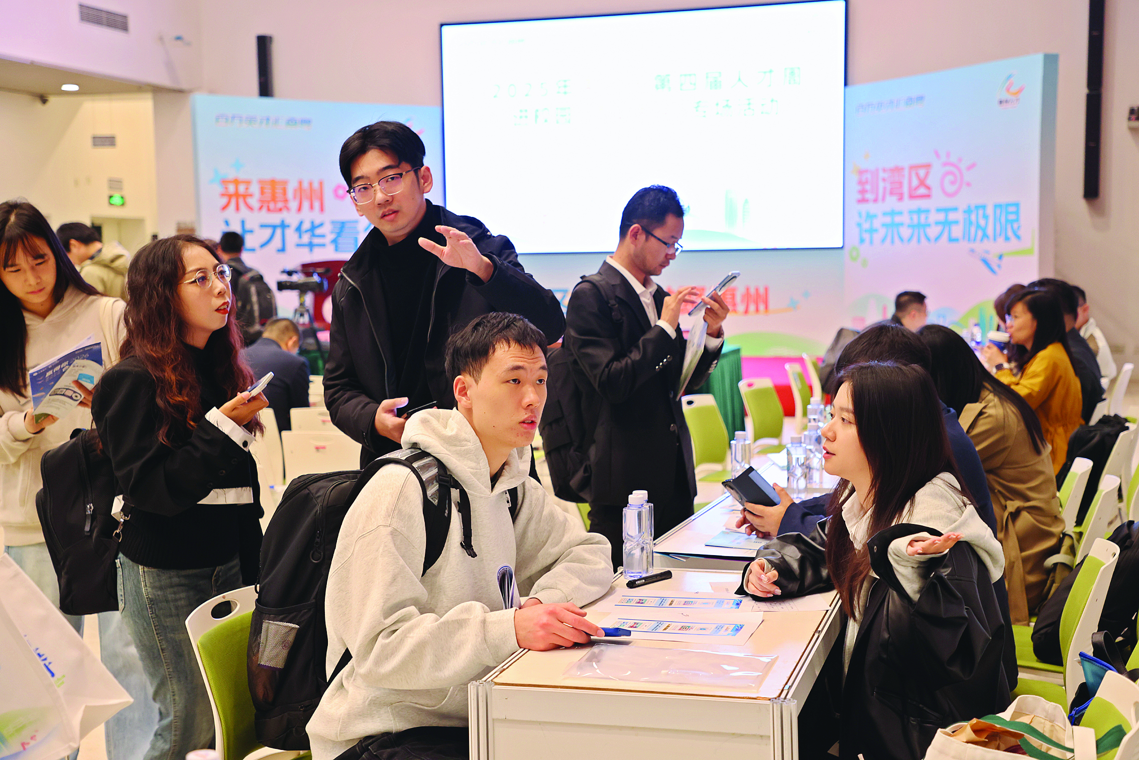     招聘人员向清华学子介绍薪资待遇。惠州日报记者王建桥 摄