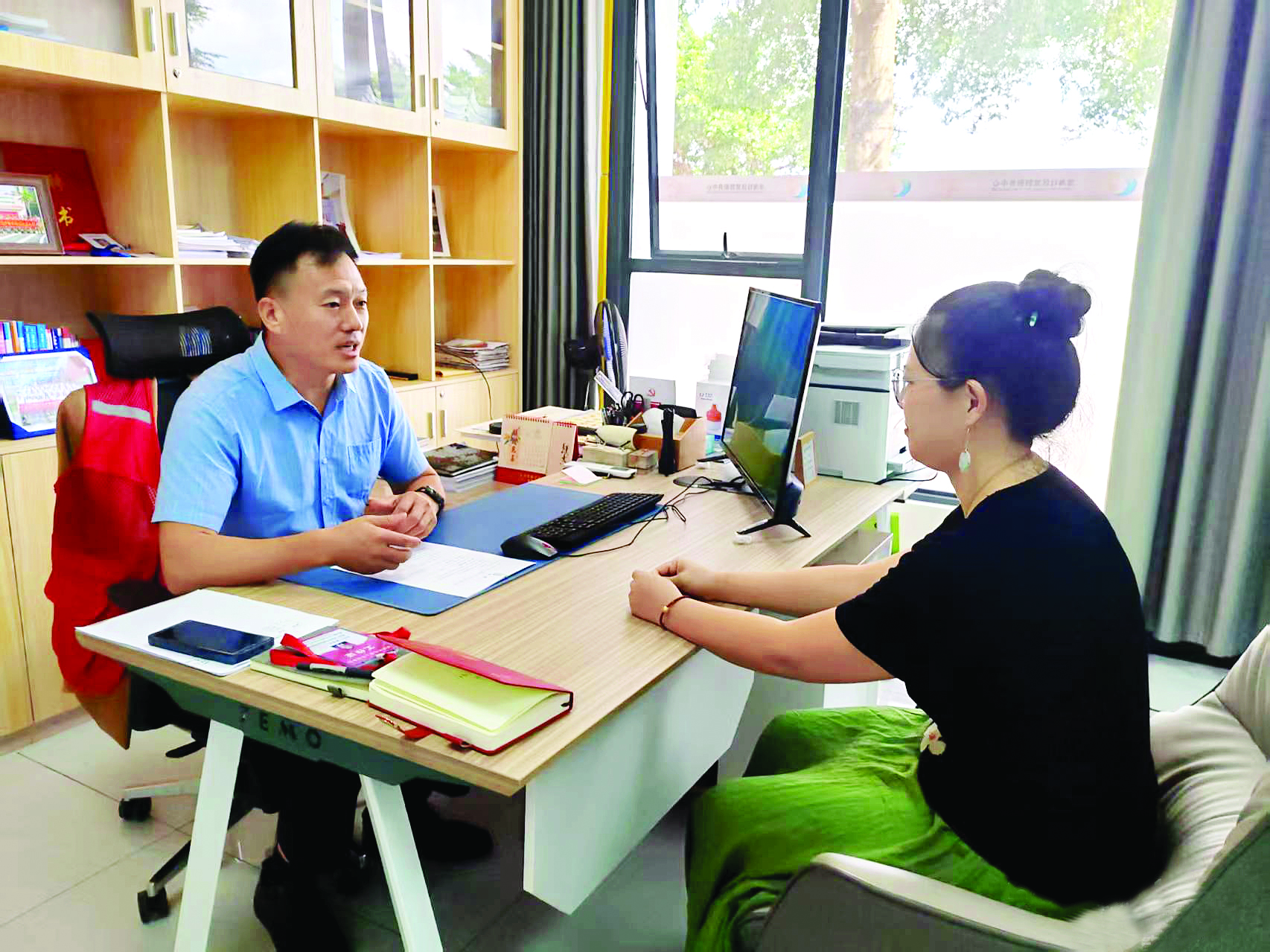     夏春培（左）和社区居民沟通交流。 