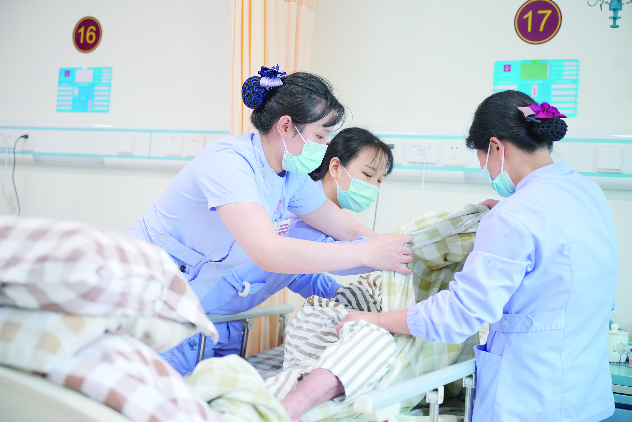     护士在帮助老人翻身排痰。