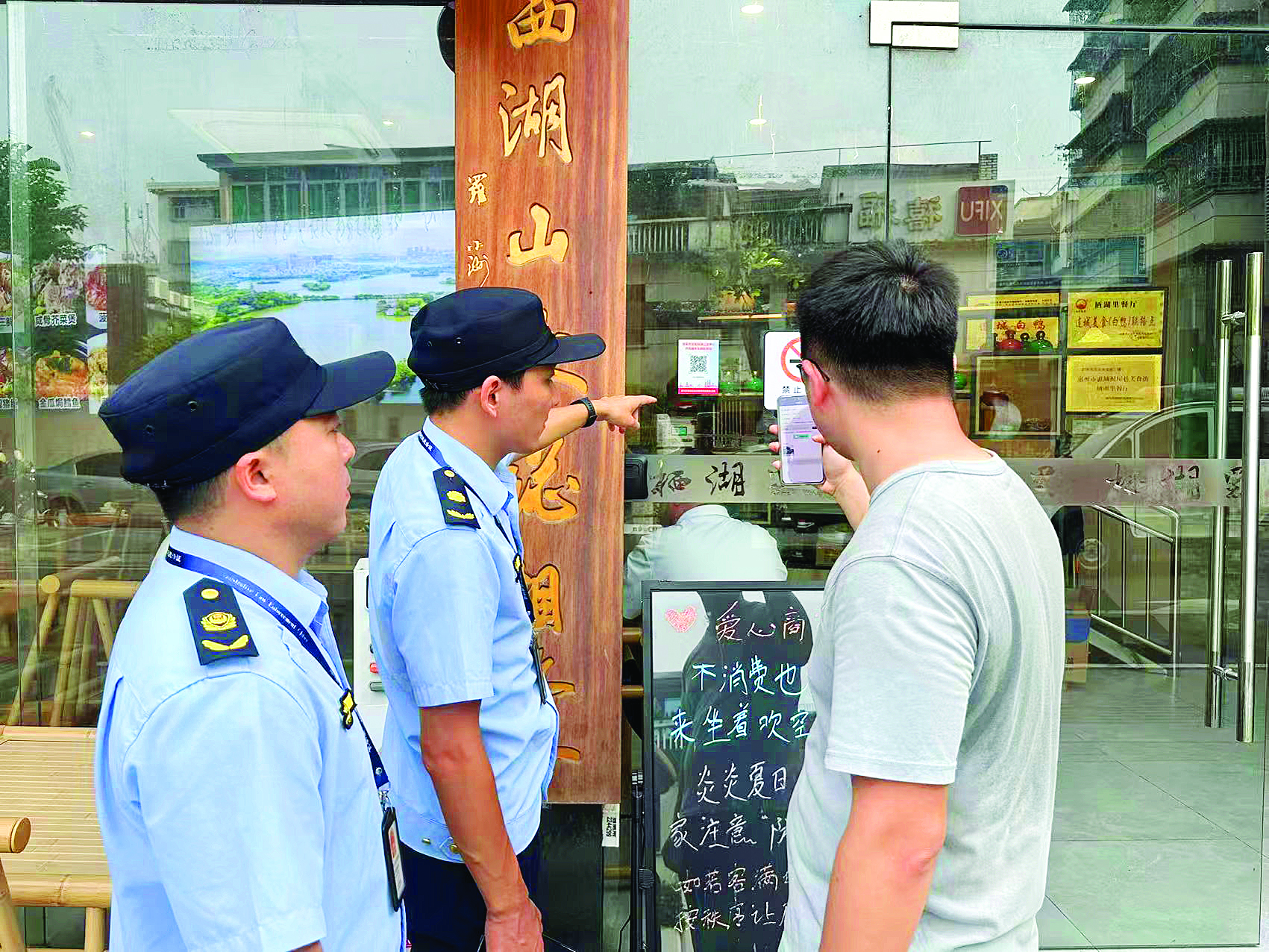     执法人员引导商户扫码了解信息。本组图片 由市城管执法局提供