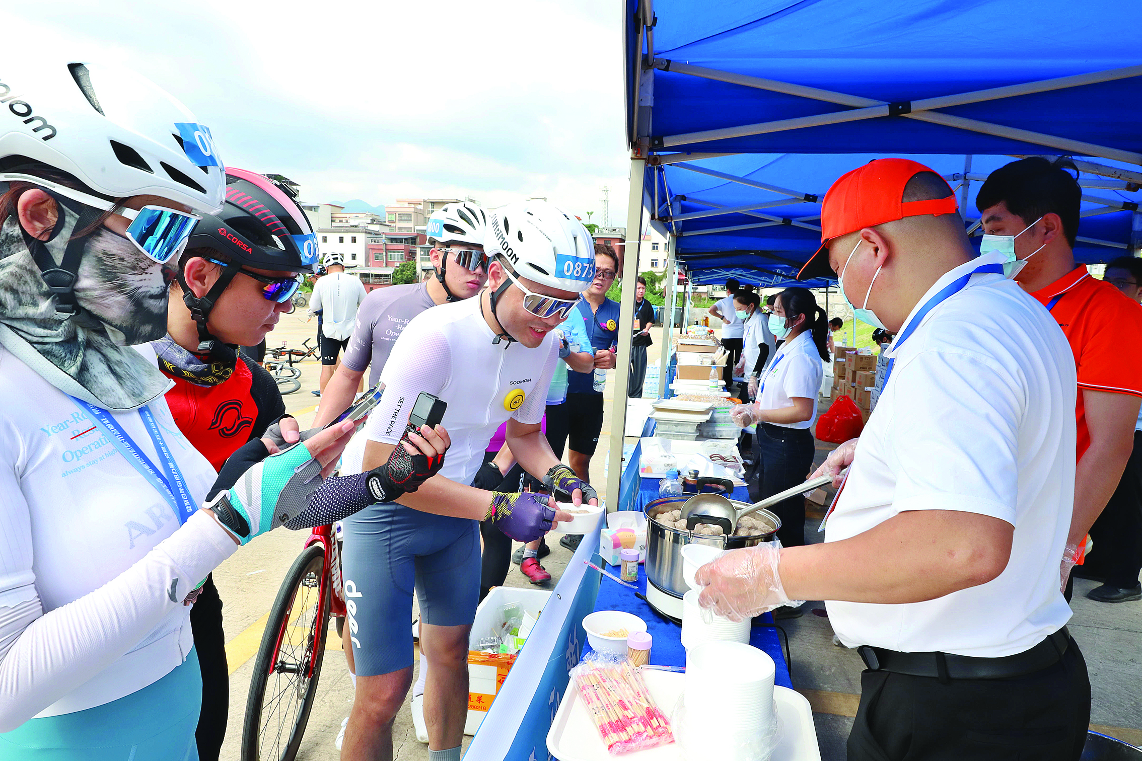     10月31日上午11时许，骑友到达龙门县永汉镇终点，品尝龙门特色小吃。    本组图片 惠州日报记者钟畅新 摄