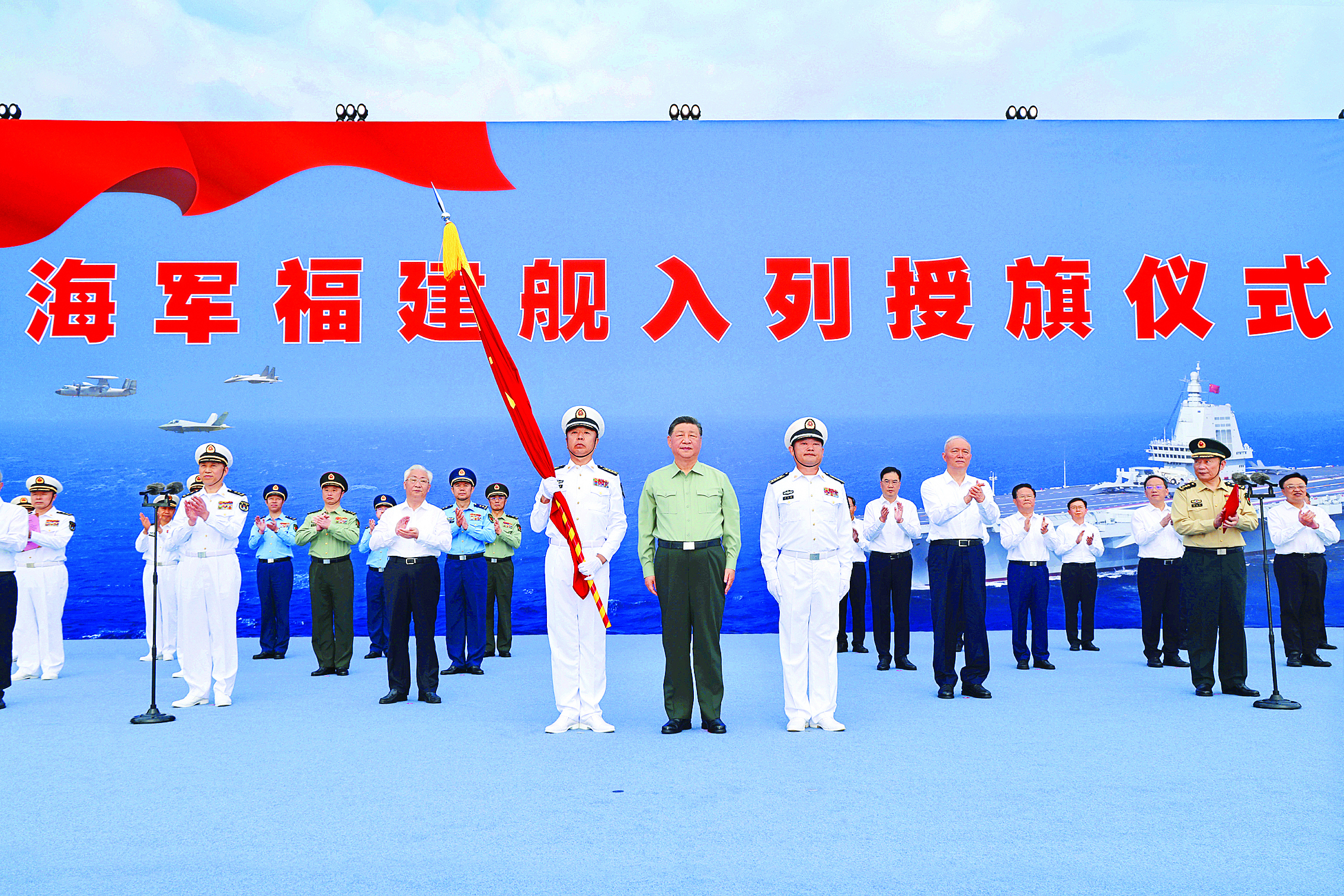     11月5日，我国第一艘电磁弹射型航空母舰福建舰入列授旗仪式在海南三亚某军港举行。中共中央总书记、国家主席、中央军委主席习近平出席入列授旗仪式并登舰视察。这是习近平向福建舰舰长、政治委员授予军旗。新华社发