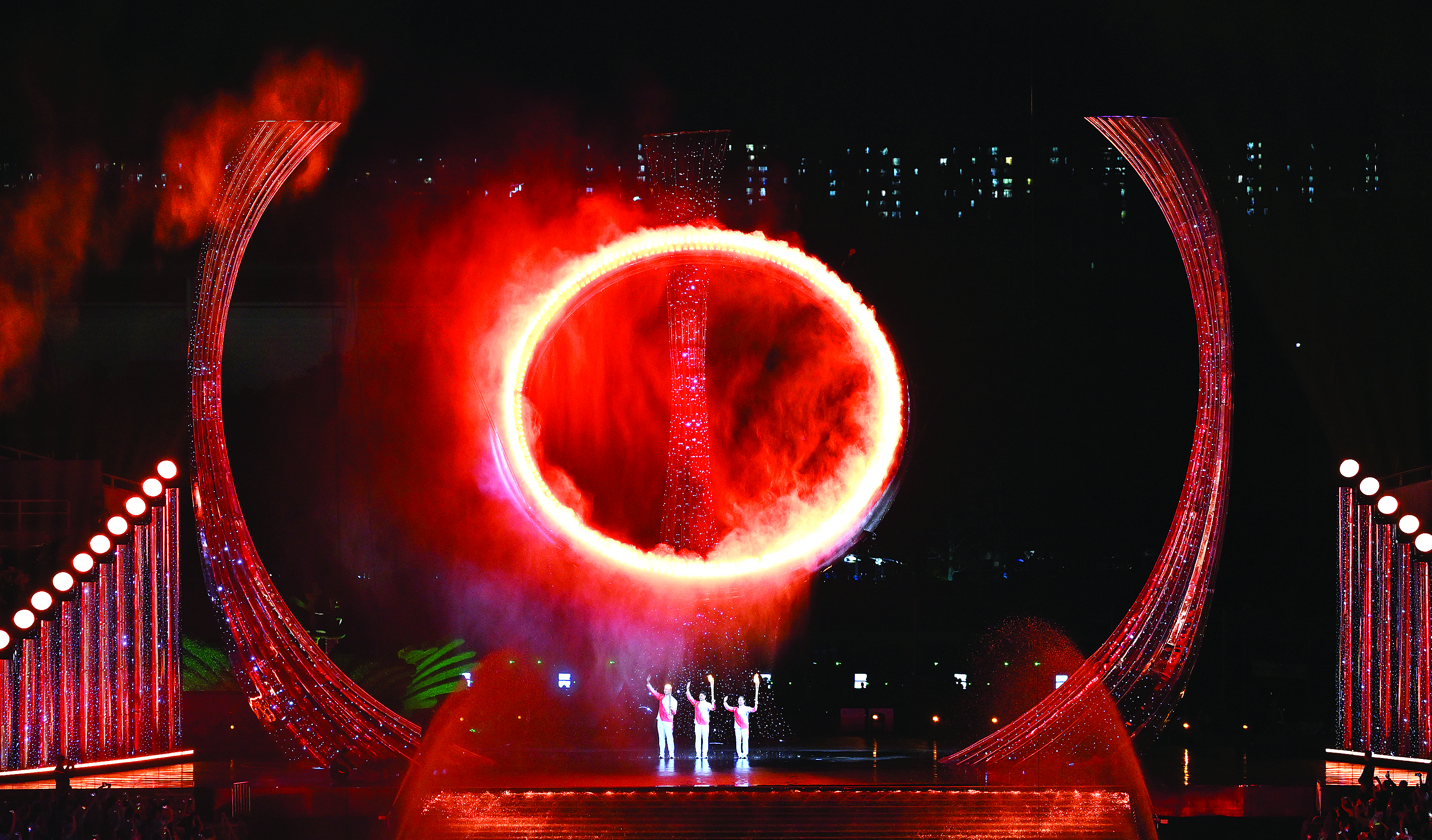     11月9日，火炬手苏炳添（中）、张家朗（左）、李祎点燃主火炬后向观众致意。当日，第十五届全国运动会开幕式在广东     奥林匹克体育中心举行。本版图片（除署名外） 新华社发