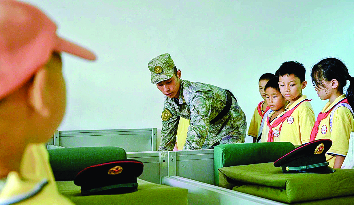     学生在军营观摩叠被子。