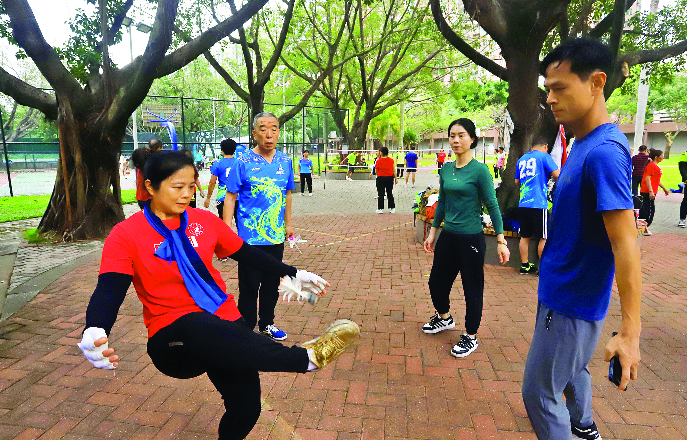     市民在滨江公园踢毽球。