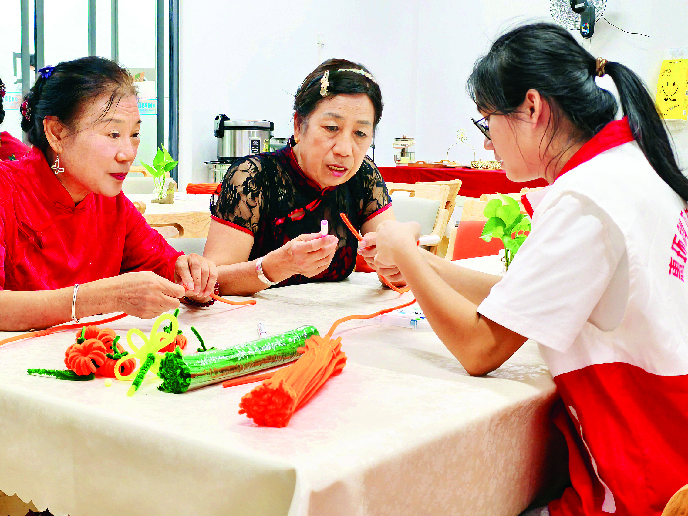     在志愿者的指导下，阿姨们学做手工。