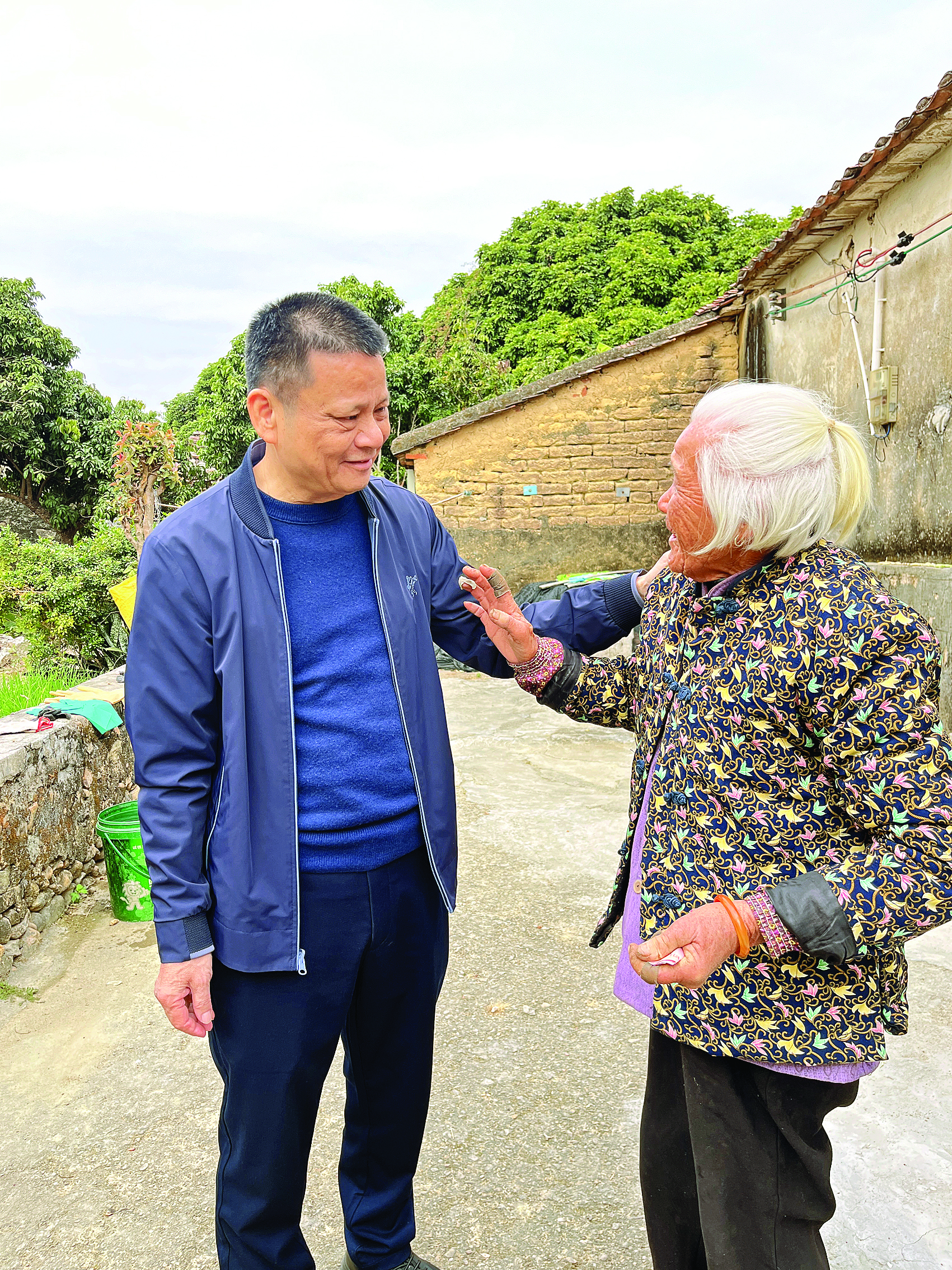     陈添胜（左）走访慰问村中老人。