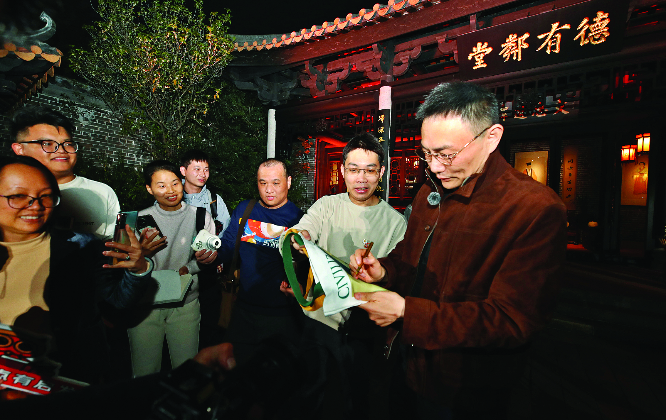     罗振宇（右一）给粉丝签名留念。惠州日报记者钟畅新 摄