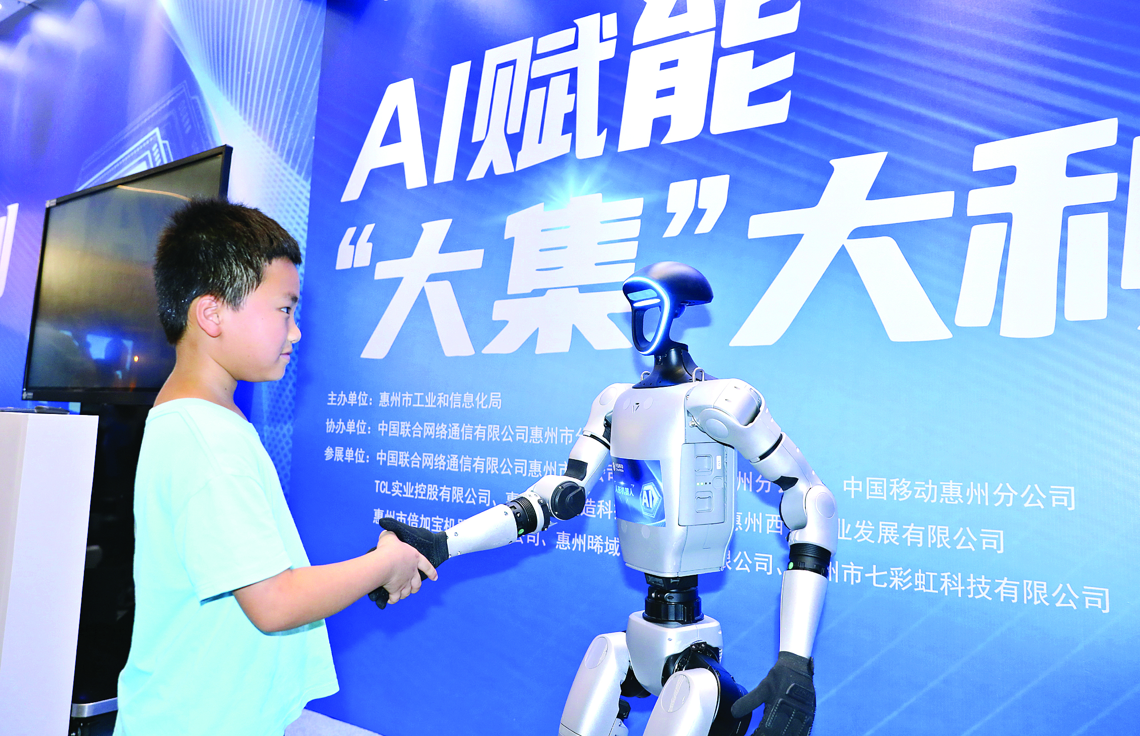     “AI赋能‘大集’大利”活动现场小朋友与机器人互动。