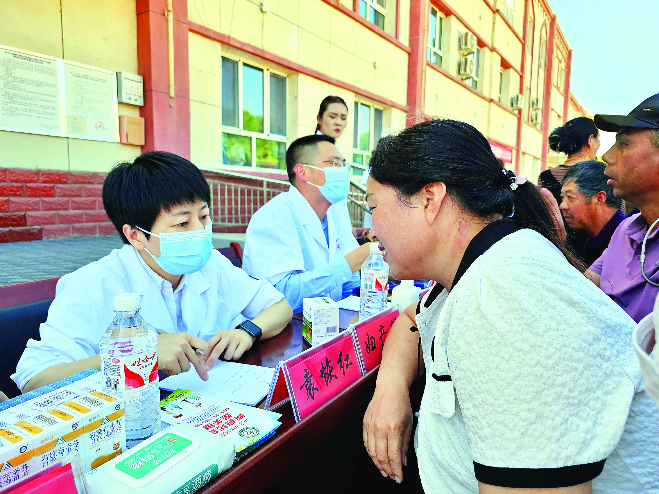     袁恢红（左一）为当地患者义诊。