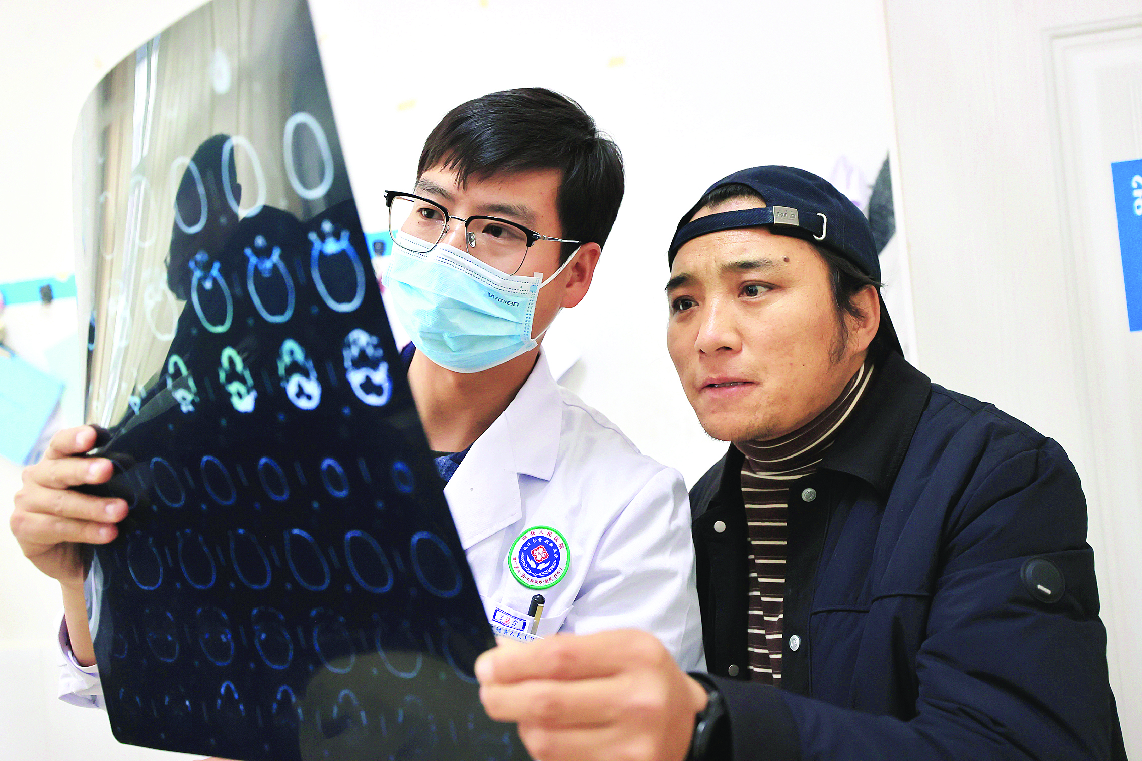     援藏医生周雄（左）为患者讲解检查结果。