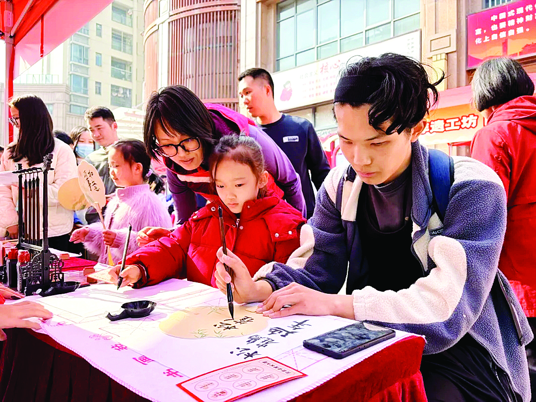     读者挥毫将新春祝福凝于扇面。    惠州日报记者钟玮 通讯员黄艳婷 摄