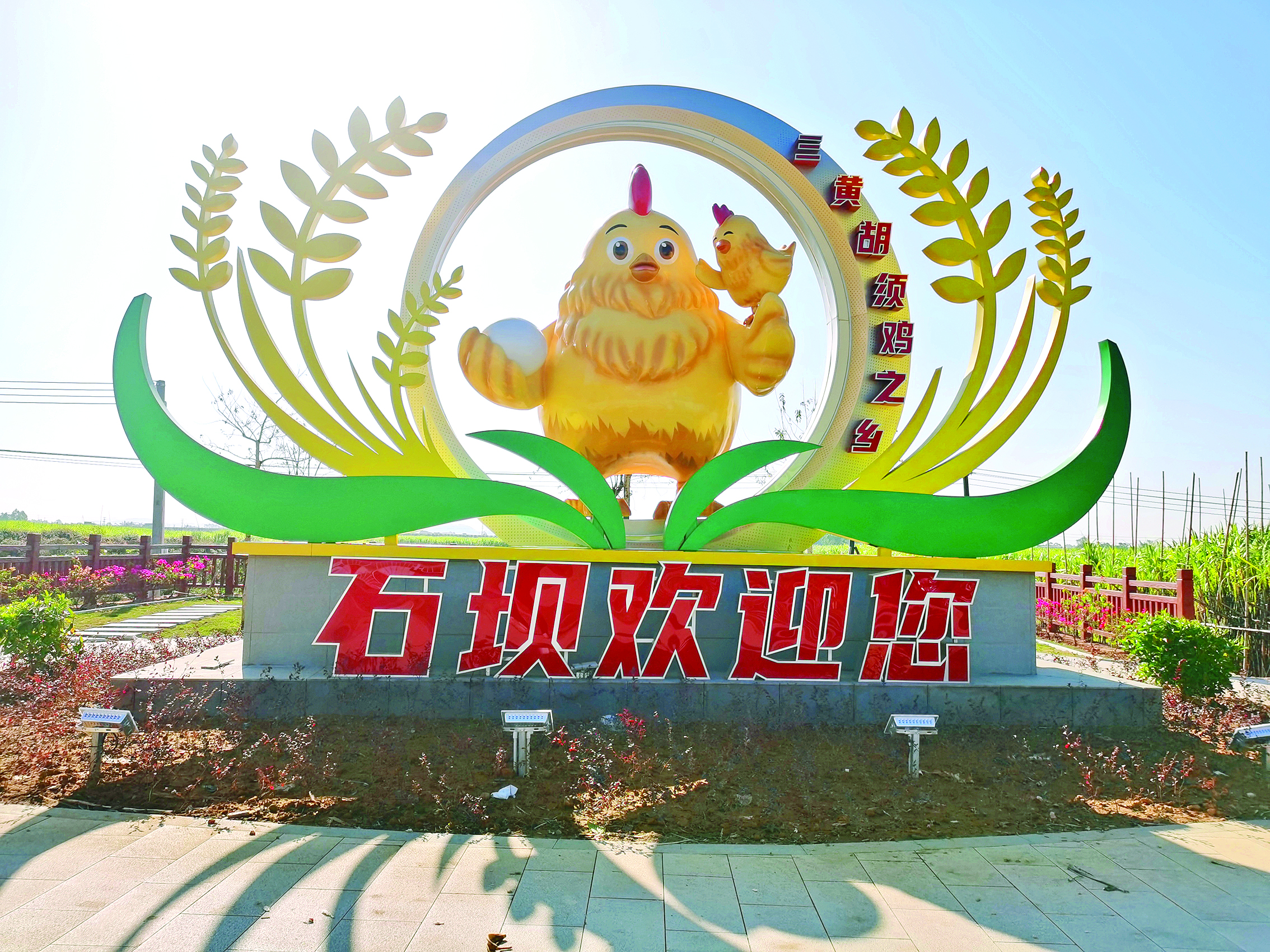     憨态可掬的“金鸡鸣”镇标矗立石坝镇入口。