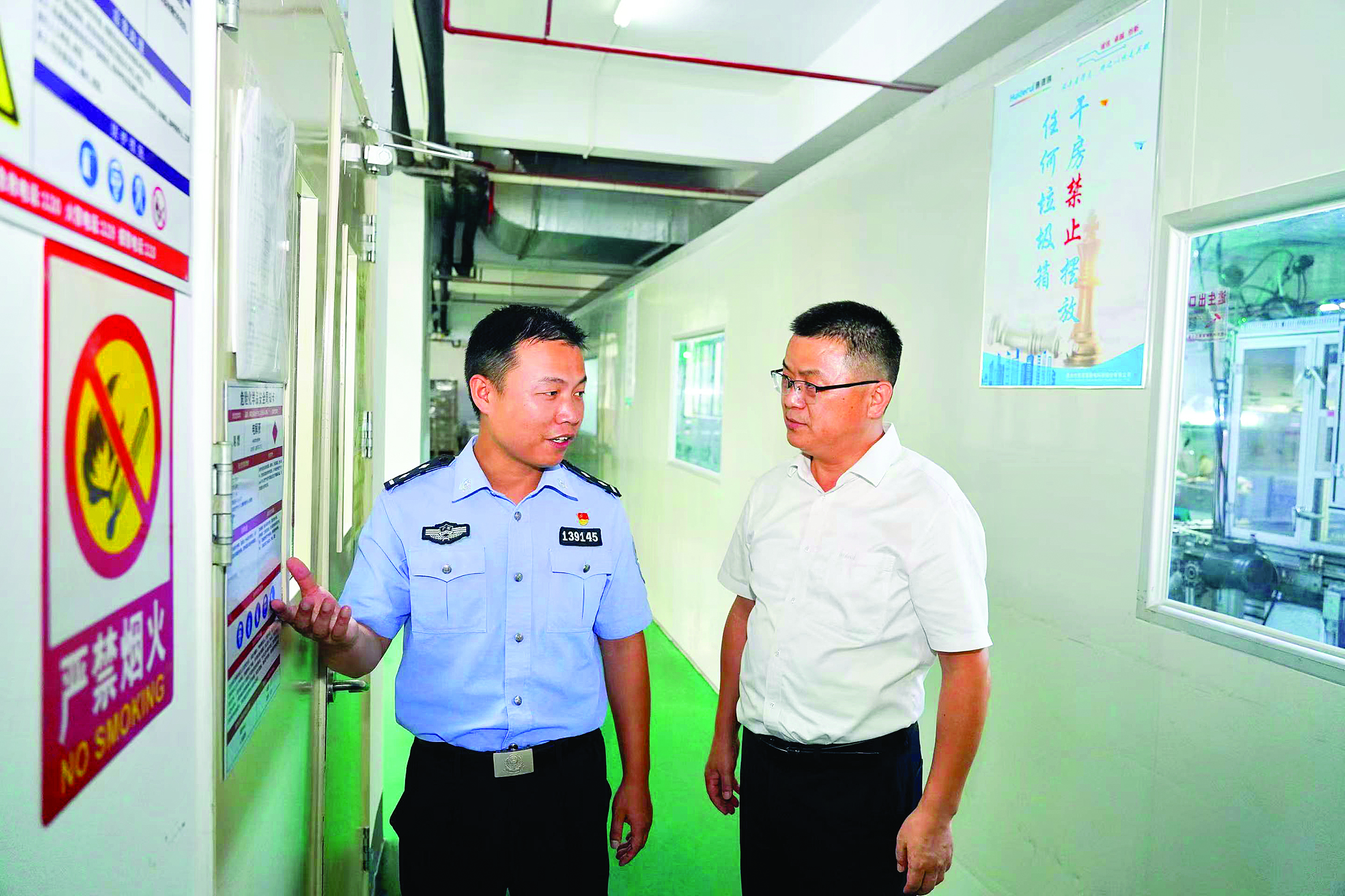     邹燎原（左）到辖区企业开展安全防范提醒。