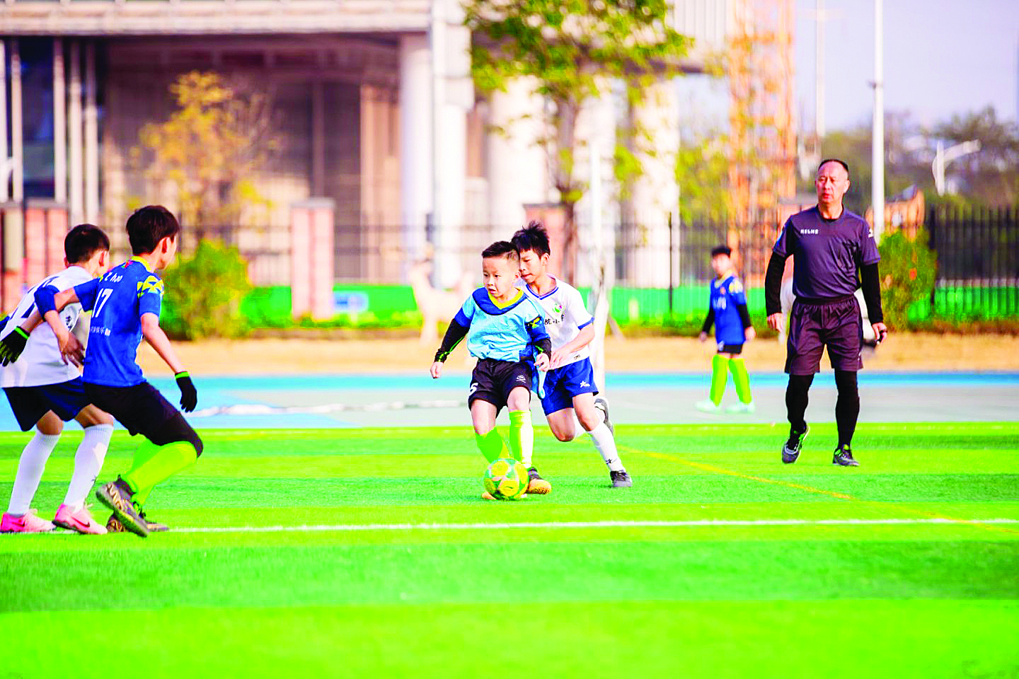     孩子们奔跑在校园足球联赛绿茵场上。    惠州日报记者蓝斐菲 摄