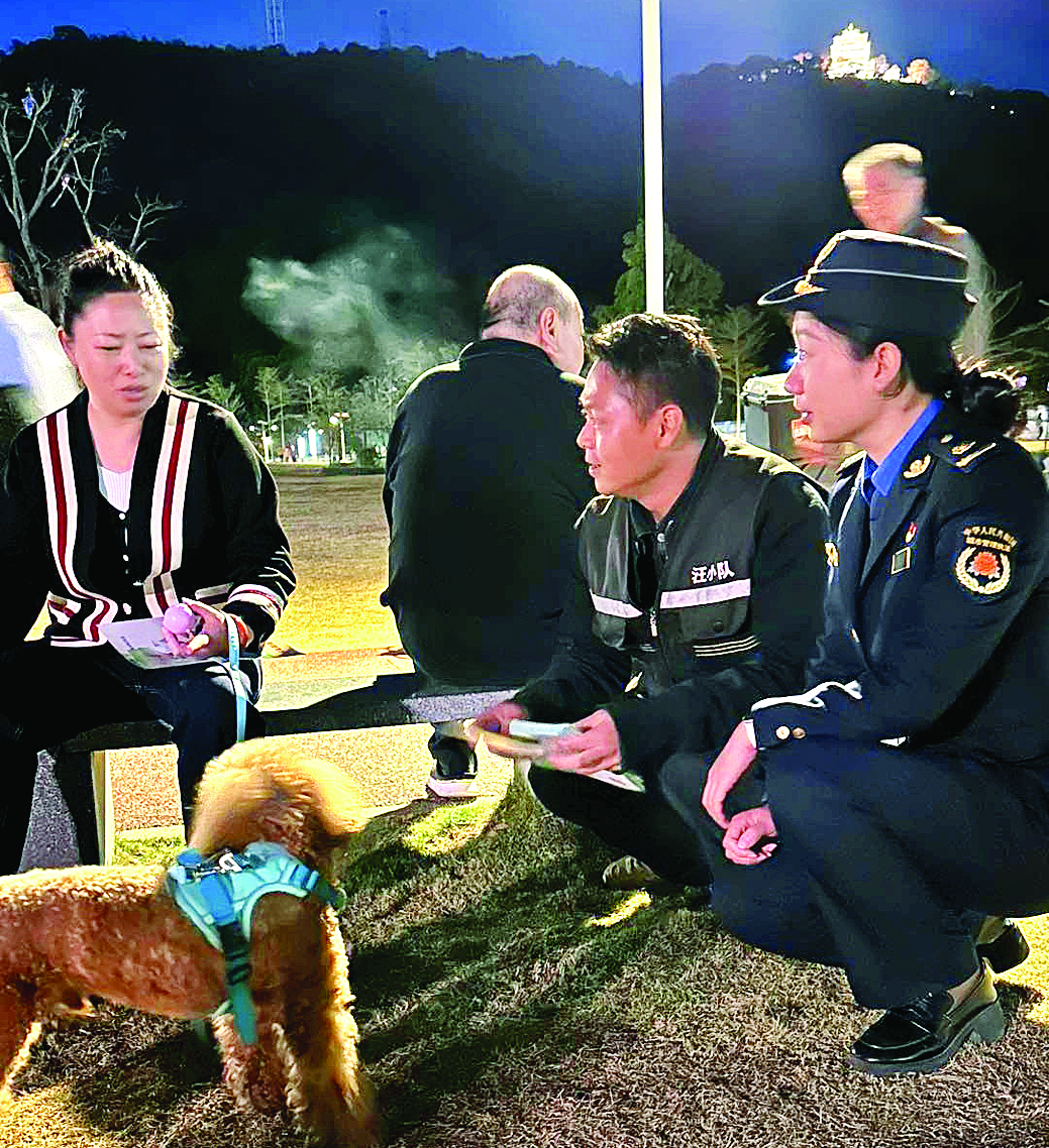     城管执法人员向市民宣传文明养犬知识。