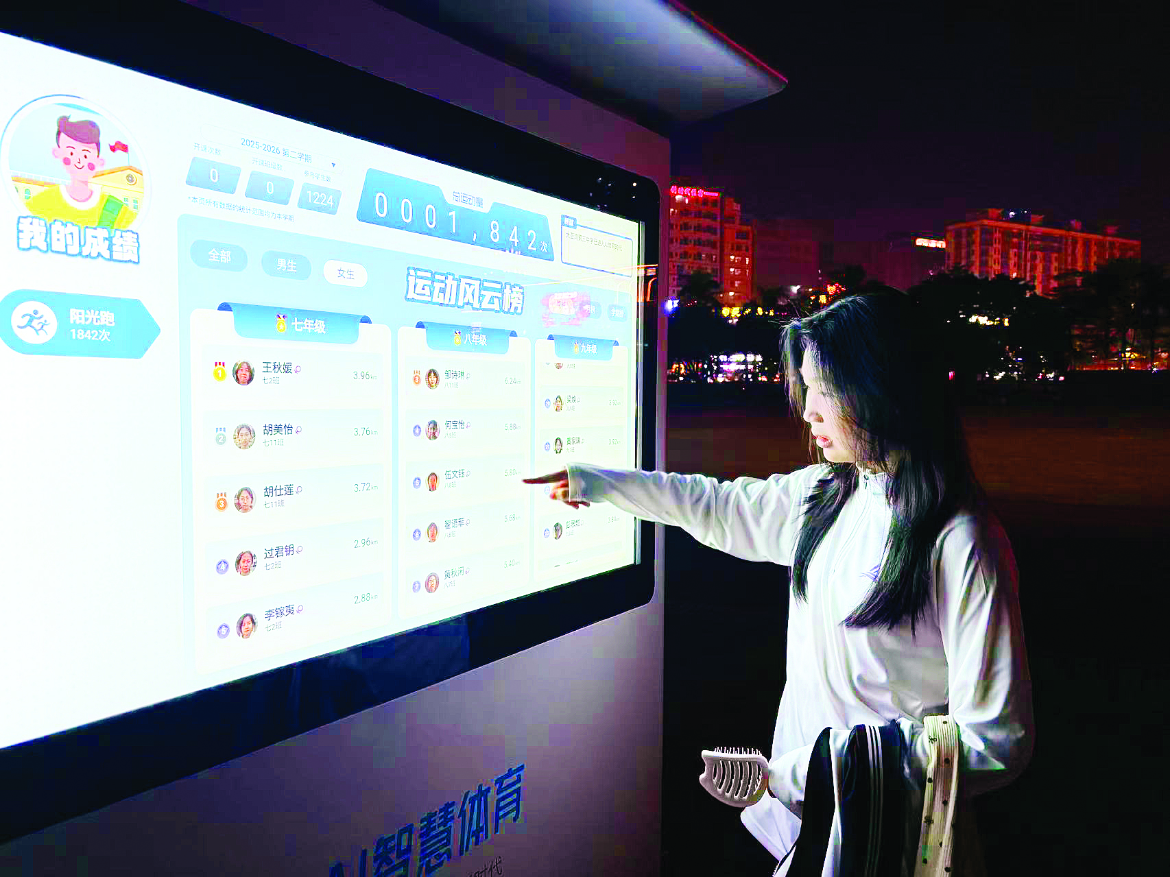     学生在查看智慧跑道上的“运动风云榜”。