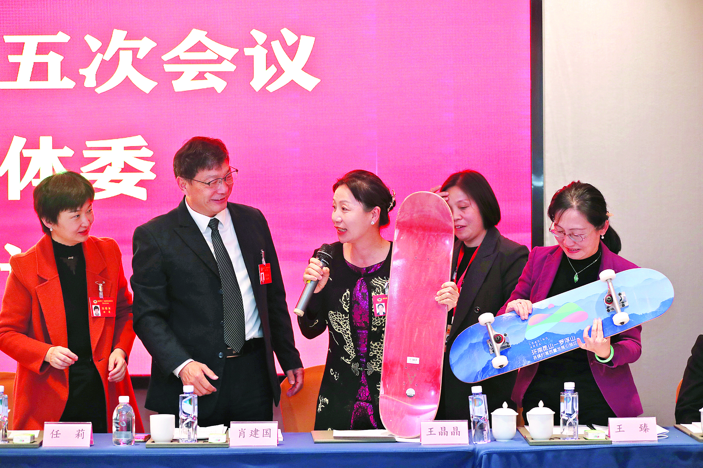     在政协分组讨论时，市政协委员王晶晶（中）带货滑板。