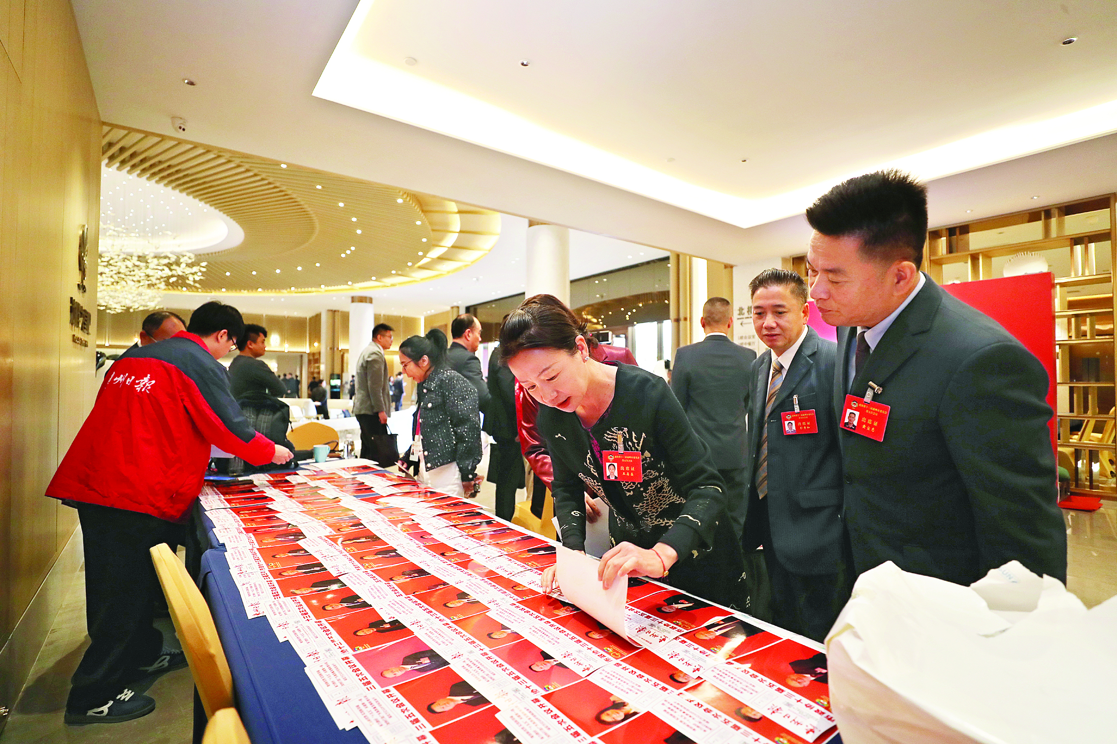     政协委员在挑选自己上“头条”的照片。惠州日报记者张艺明 摄