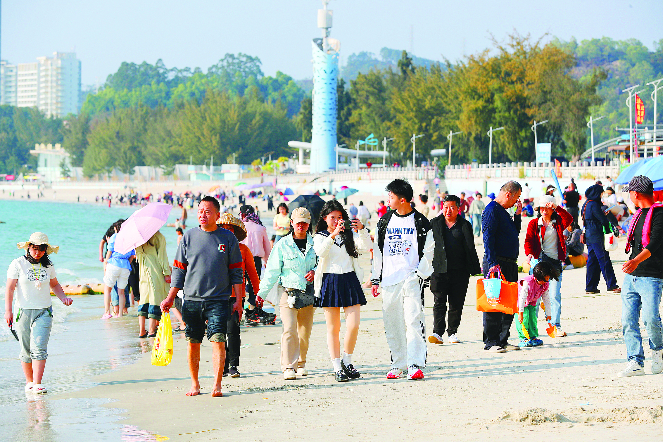     巽寮湾的碧海沙滩上，游人踏浪赏景、乐享滨海年味。惠州日报记者张艺明 摄