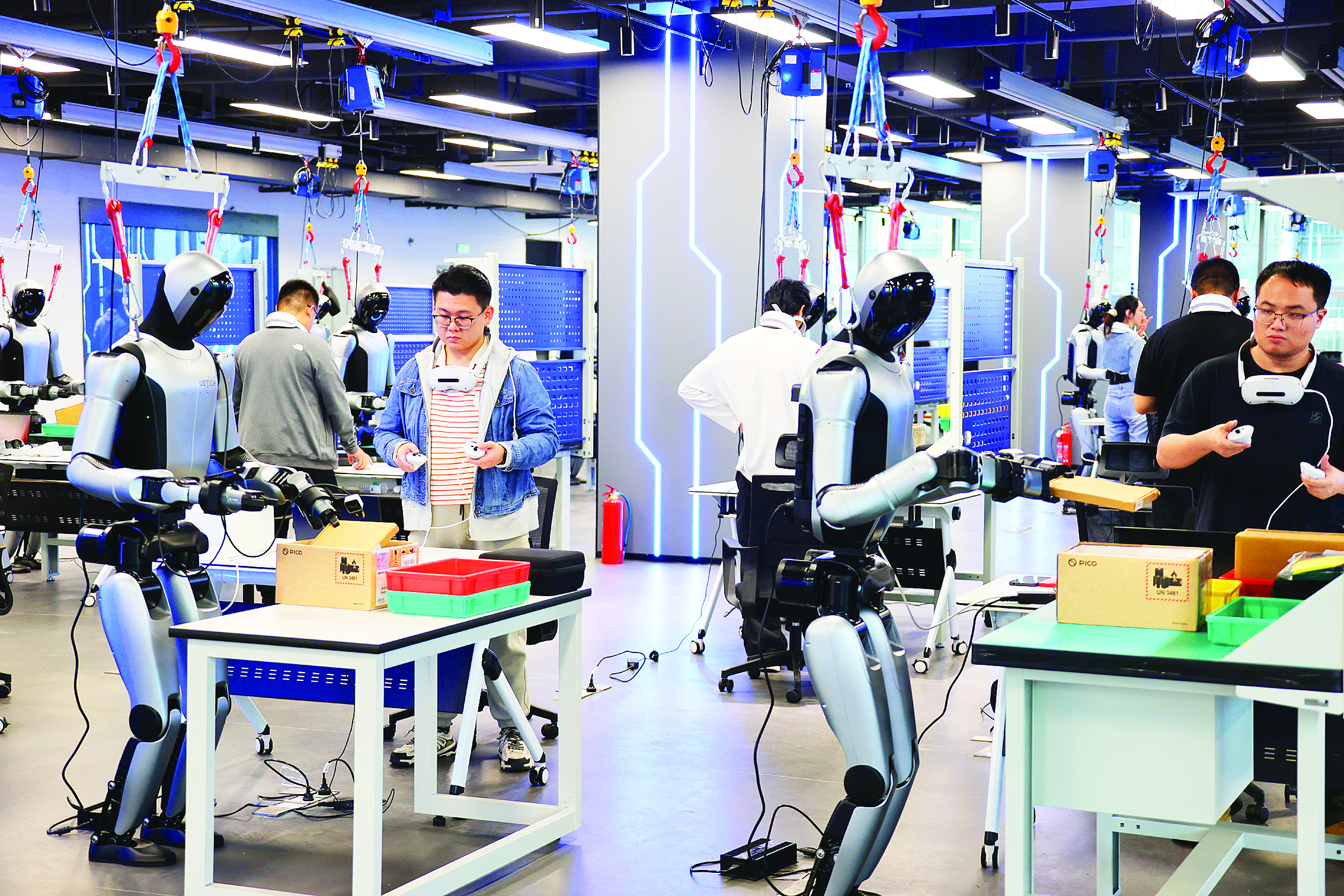     惠阳异构具身智能训练场，机器人数据采集员在认真训练人形机器人并采集相关数据。惠州日报记者李松权 汤渝杭 摄