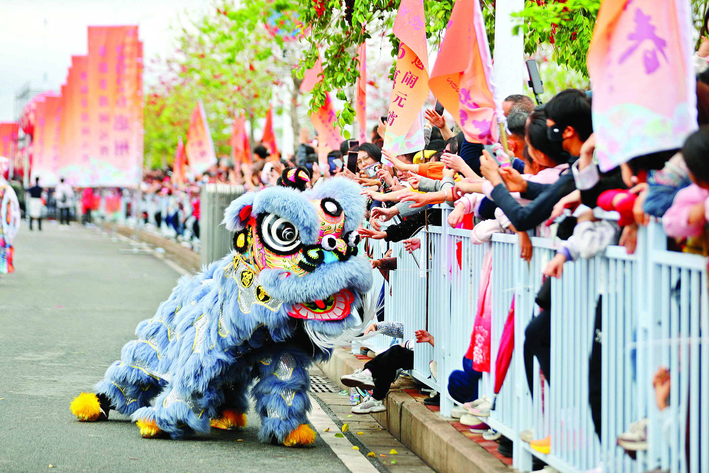 <p>    舞狮伸出狮头与观众互动。</p>