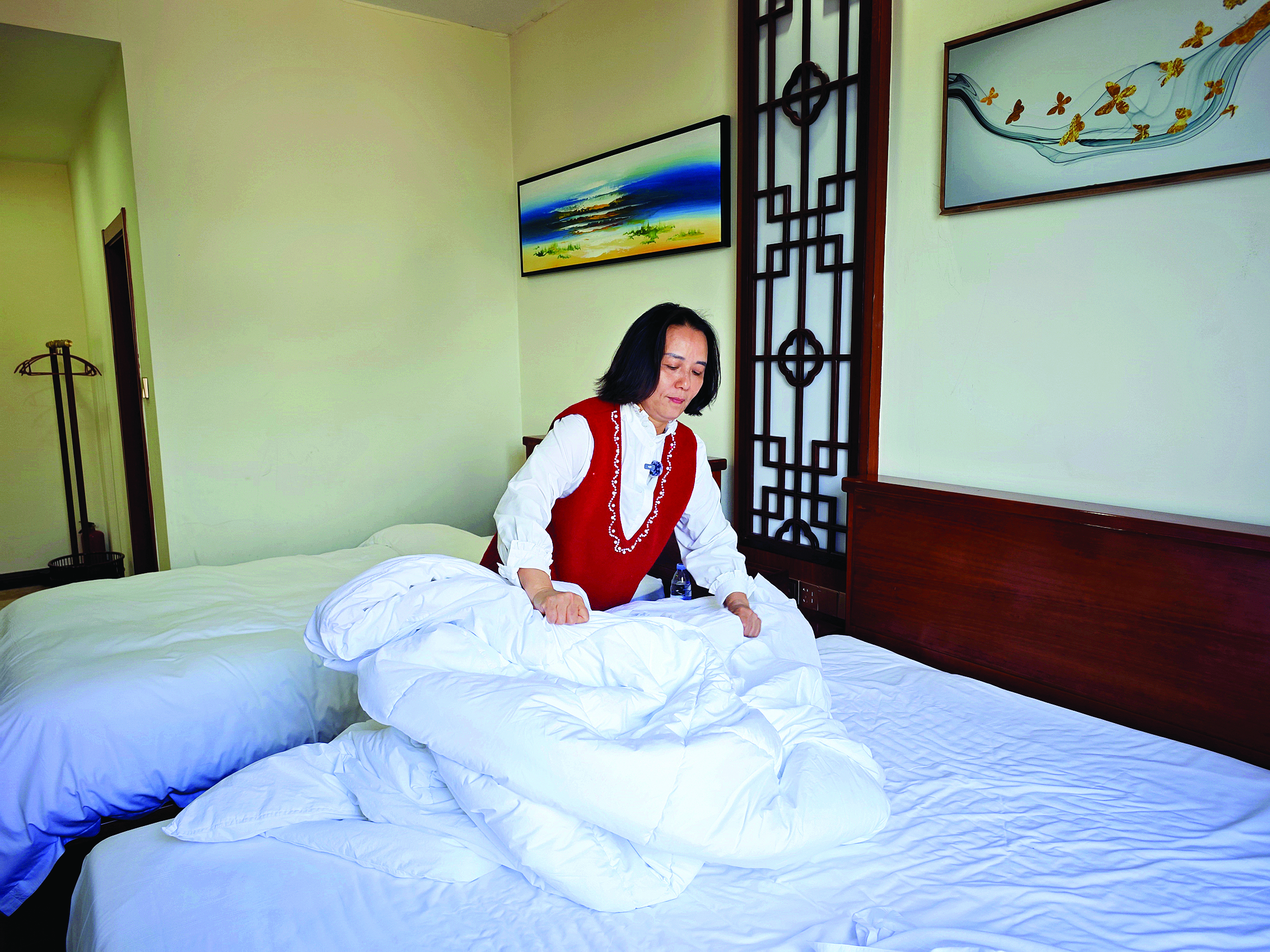     何冬媚在整理民宿客房。