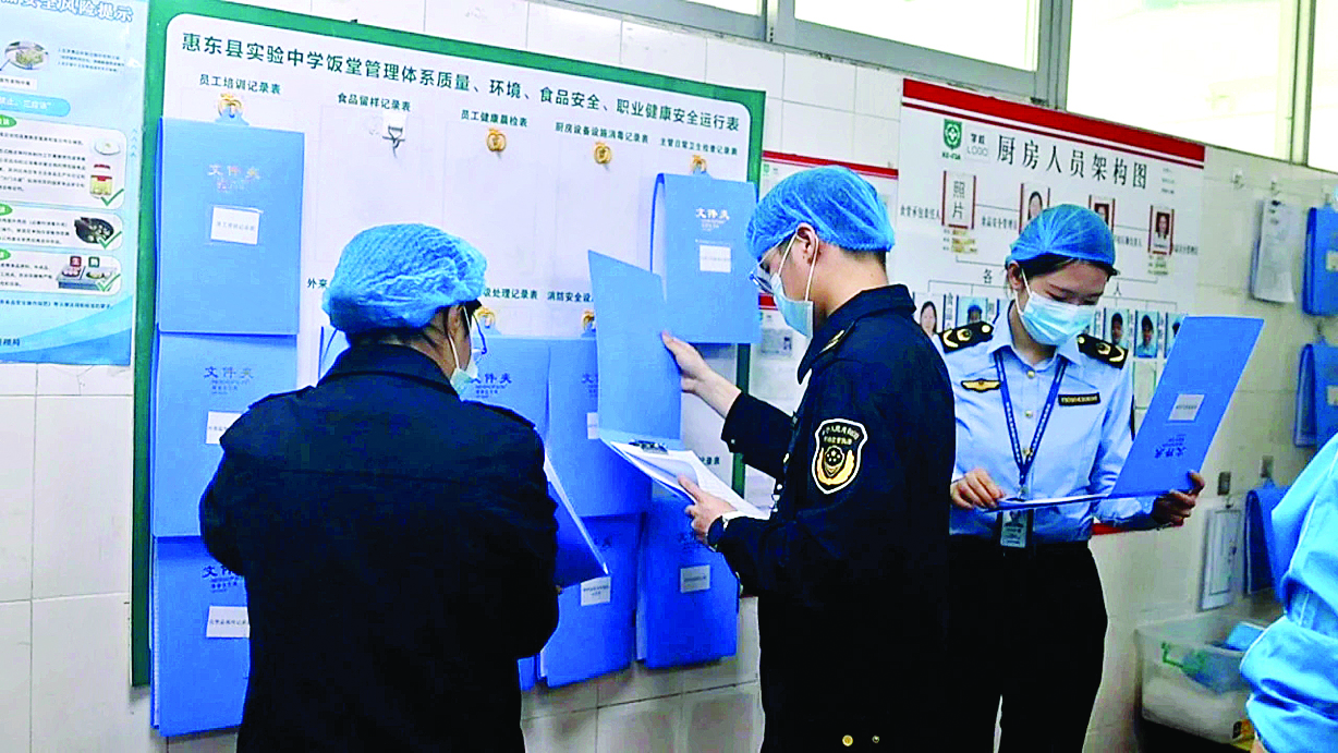     执法人员查阅食品原材料进货台账。惠州日报记者赖金朗 通讯员吕佳桐 赖悦晖 叶盈华 摄