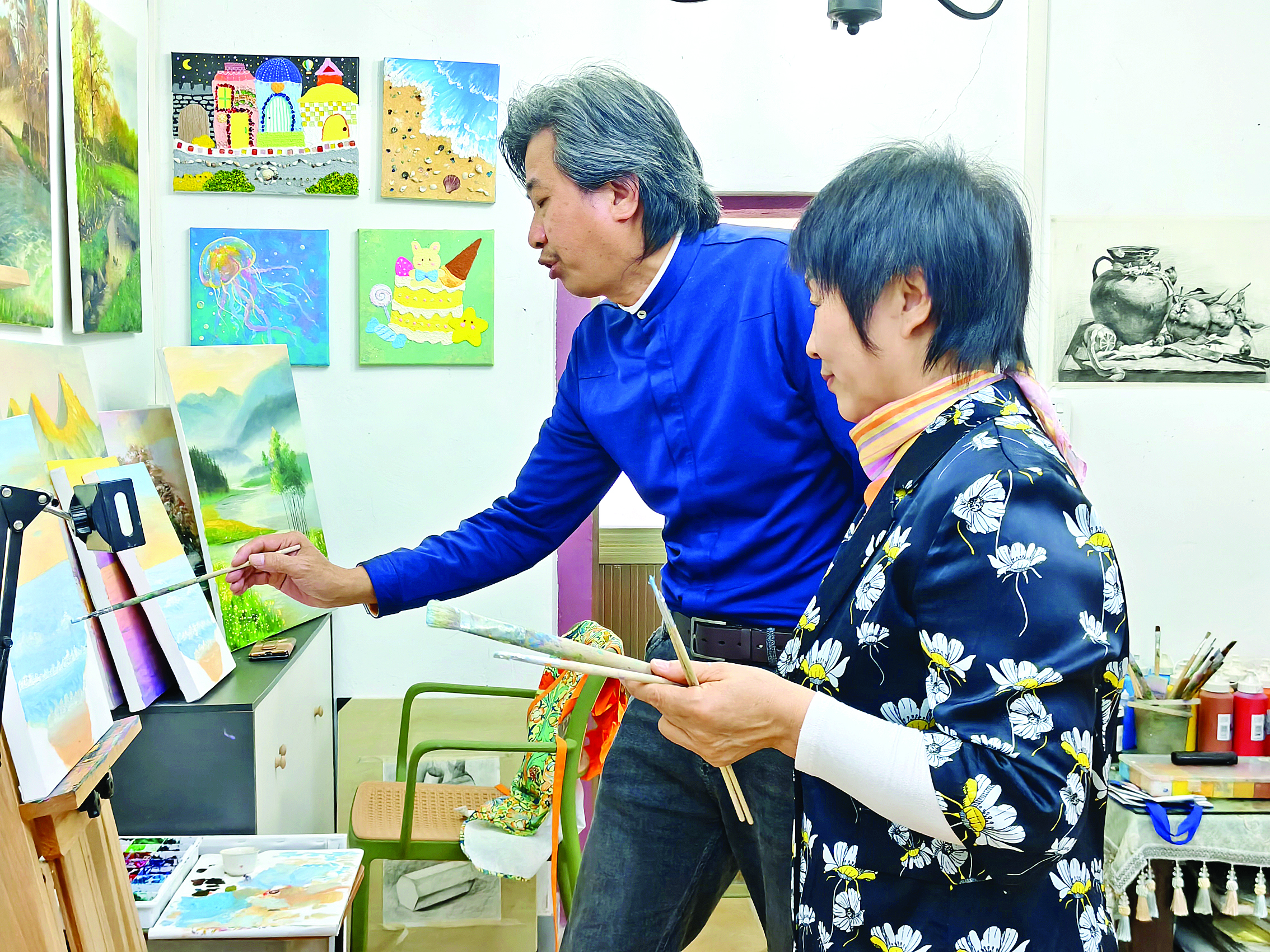     袁宜荣（左）教俱乐部成员画画。